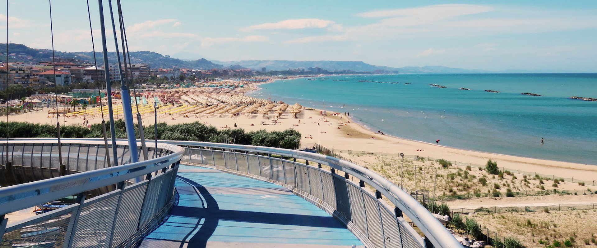 an abstract photo of a curved building with a blue sky in the background