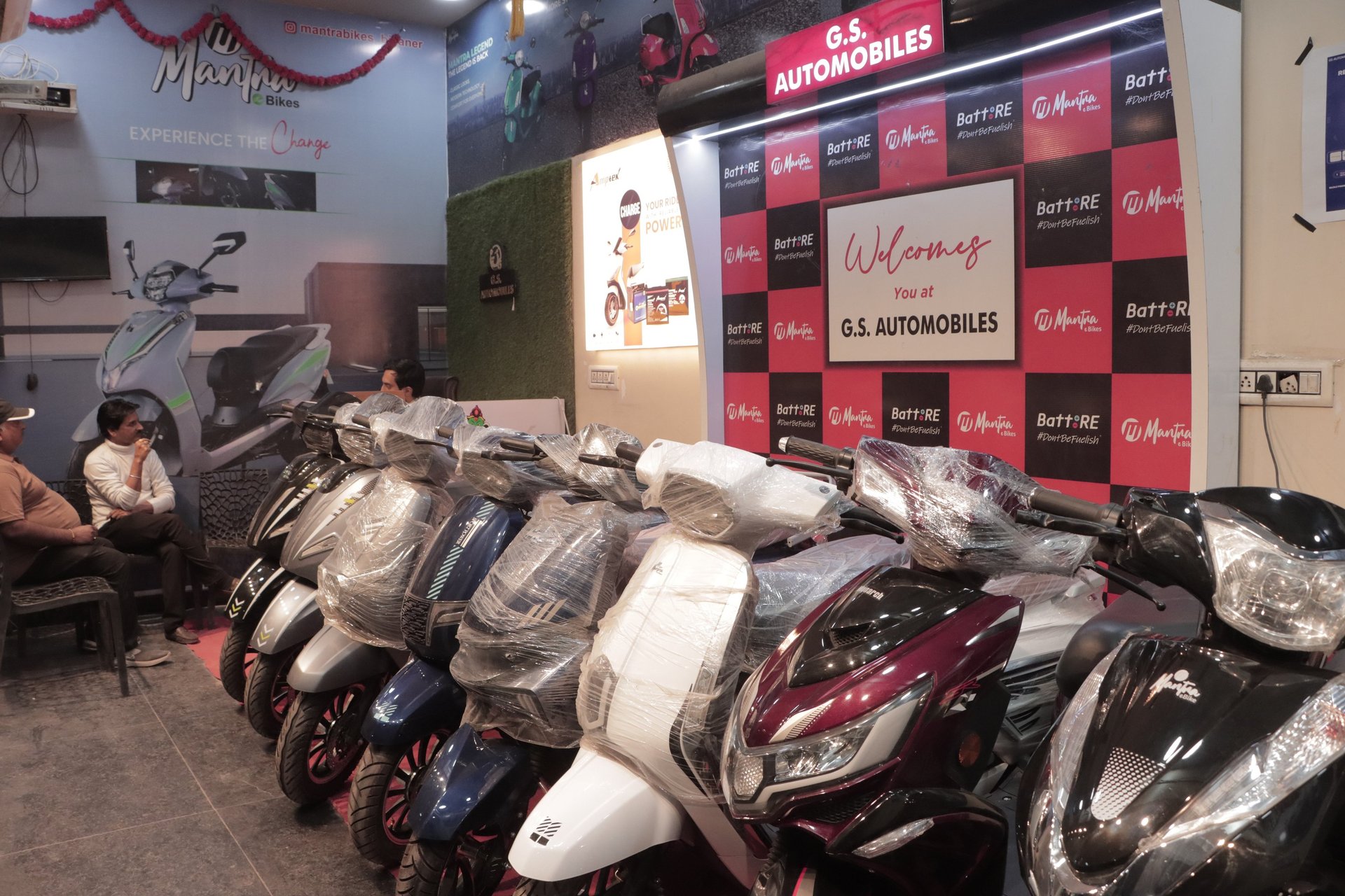 two green and red motor scooters parked on road beside building