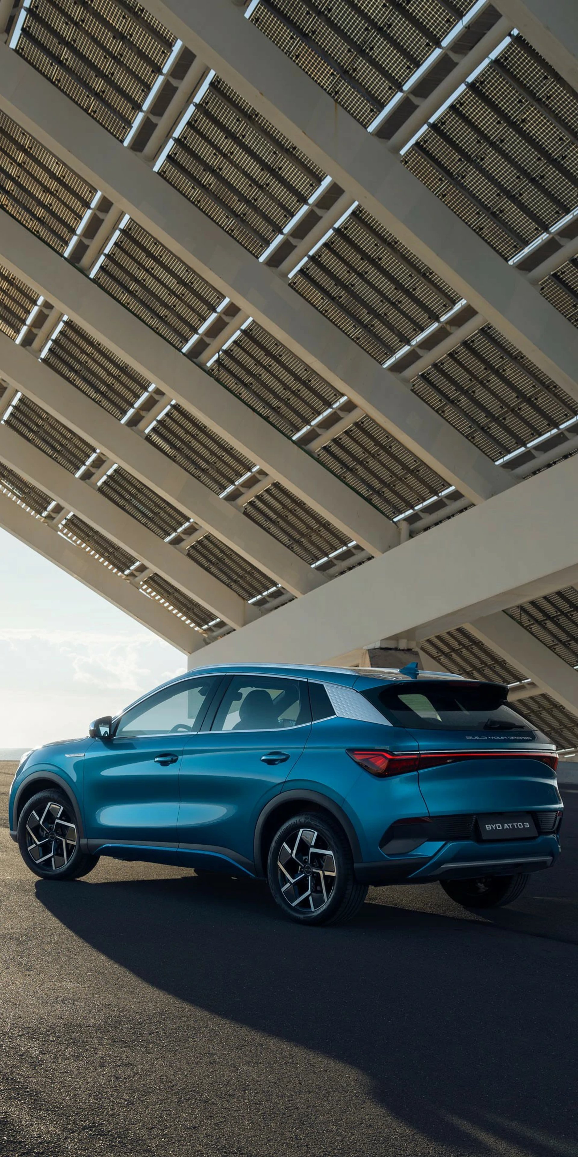 an abstract photo of a curved building with a blue sky in the background