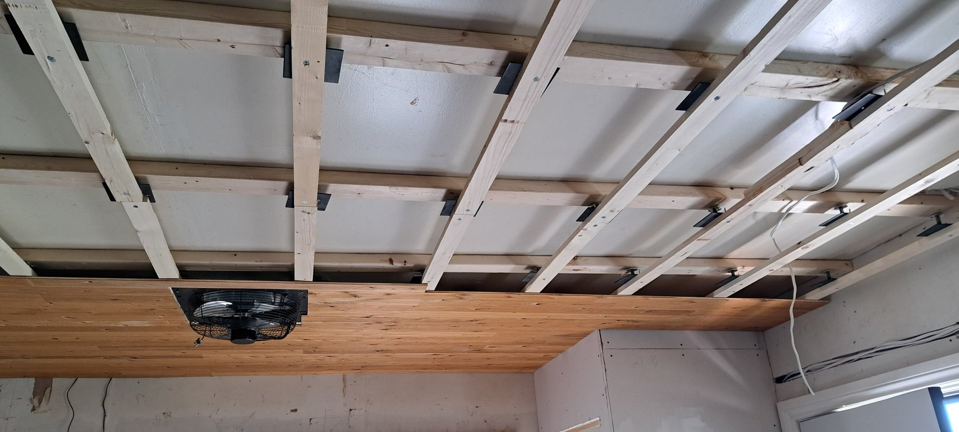 Wood ceiling framing installation in progress for residential levelling renovation project in Canada