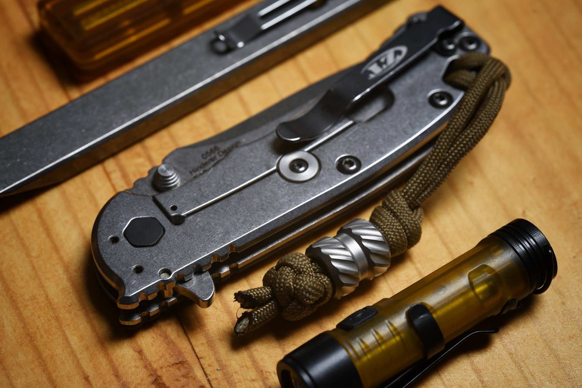 red and silver pocket knife beside black and silver camera lens