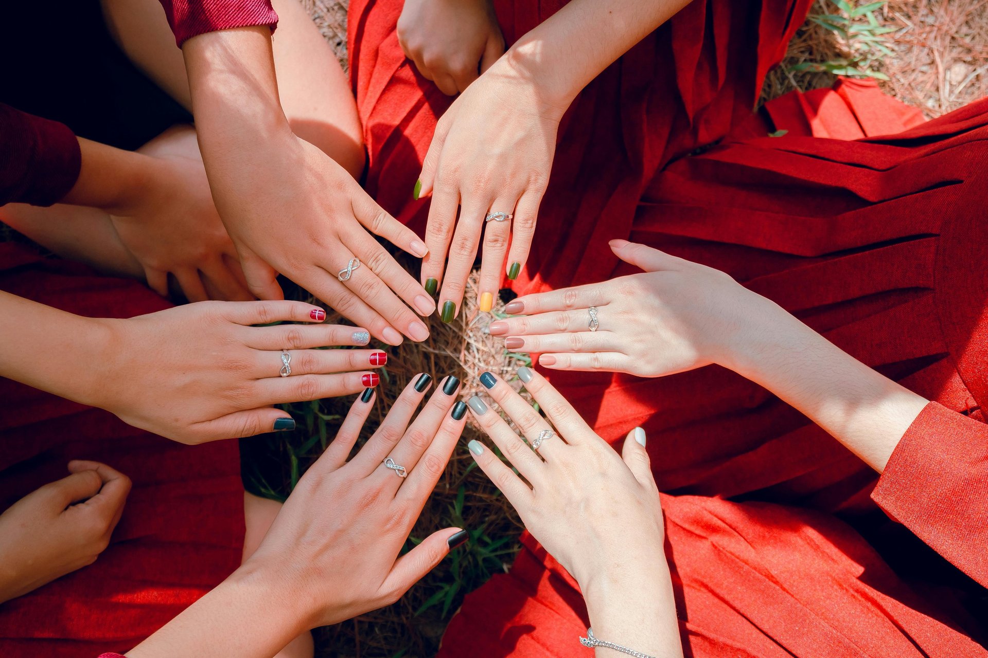 person with pink manicure on white textile