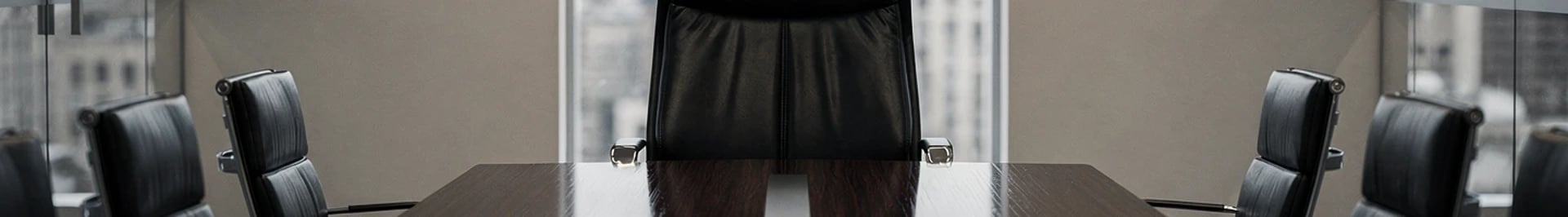 Empty chair at the head of a boardroom table, representing a missing after-sales leadership role in strategic decision-making