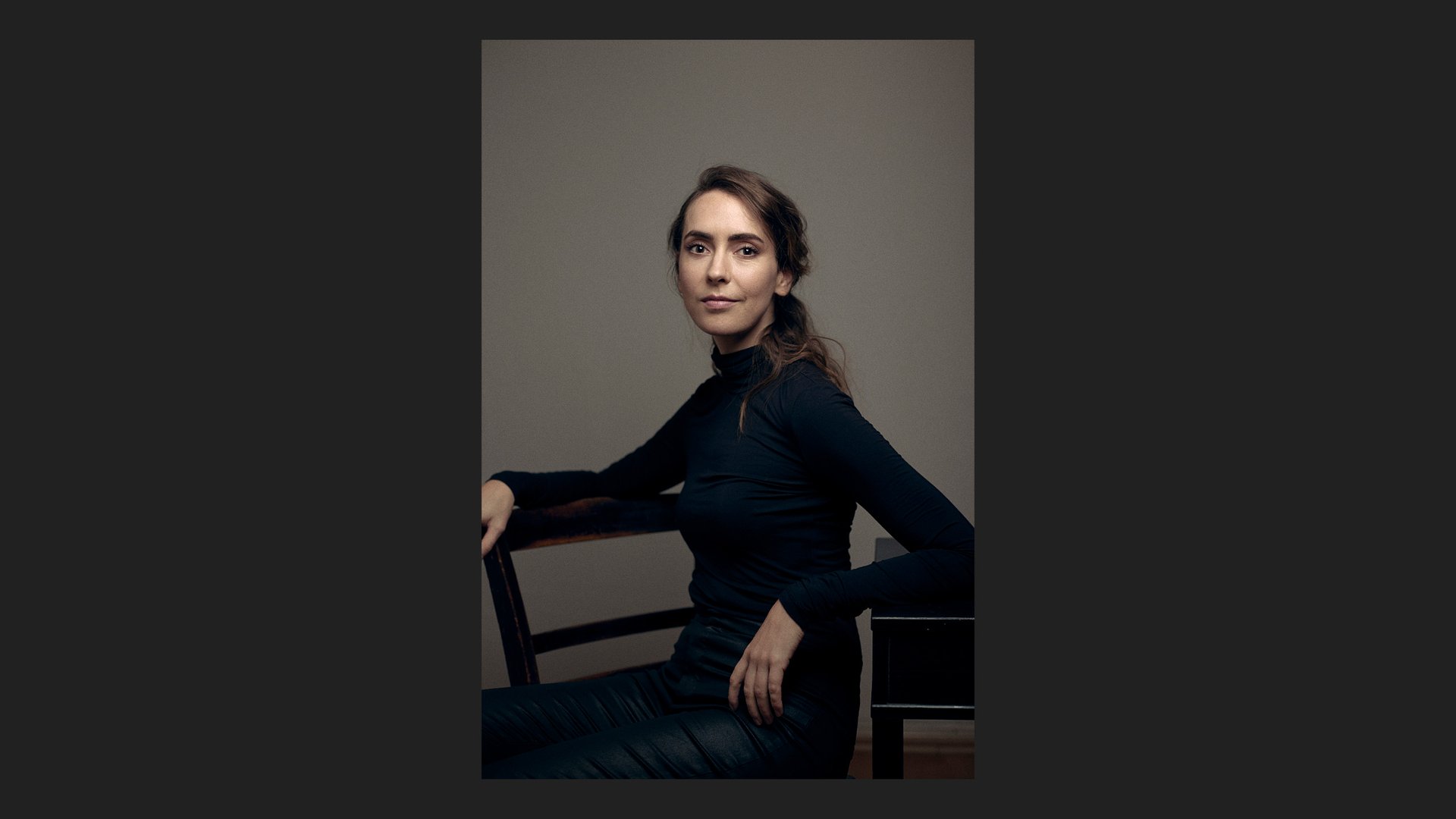 Eine Frau sitzt auf einem Stuhl in einem Fotostudio.