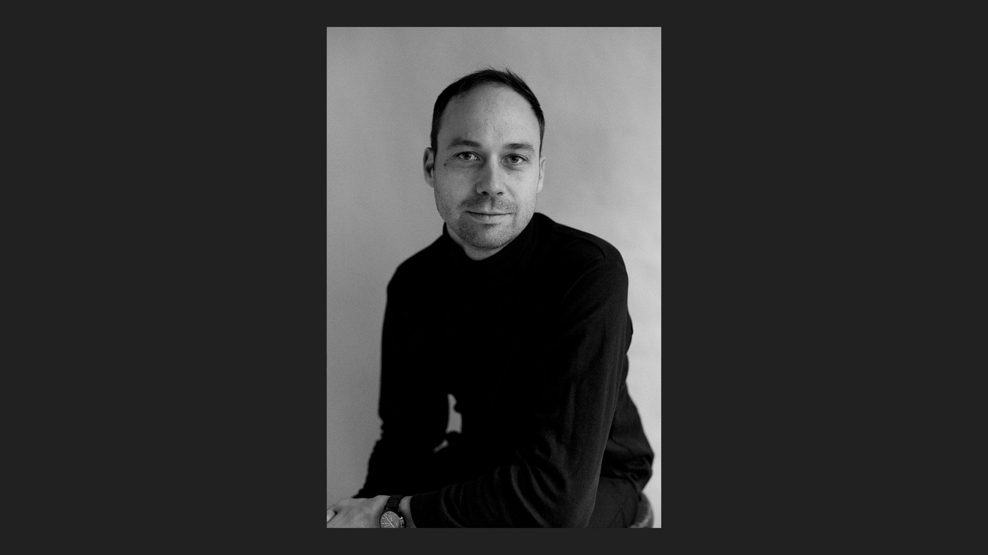 Nikolas Lelle in a turtle neck photographed in a studio.