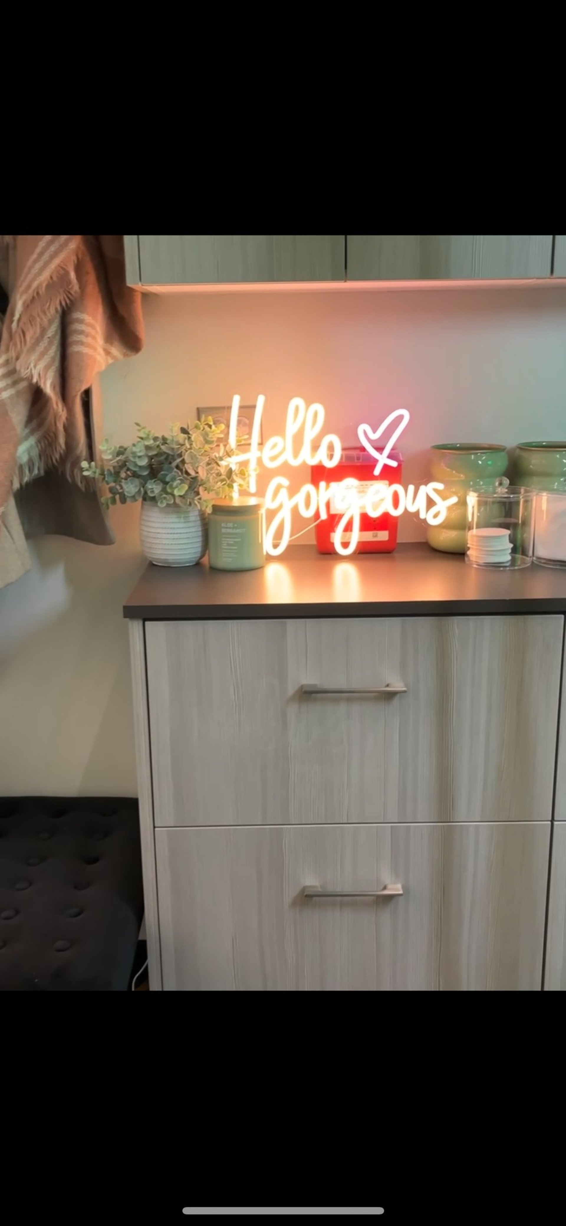 A neon sign says "hello gorgeous".