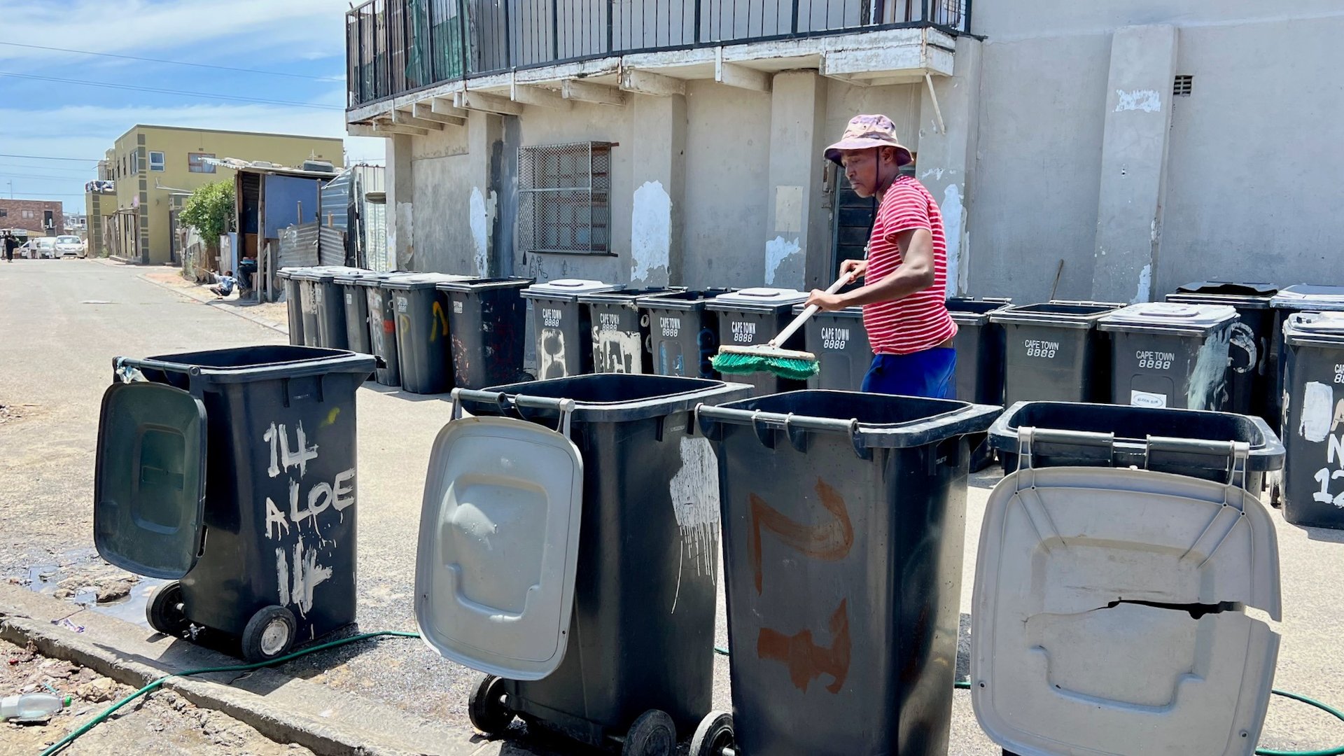 A narrow alley way with trash cans on the floor