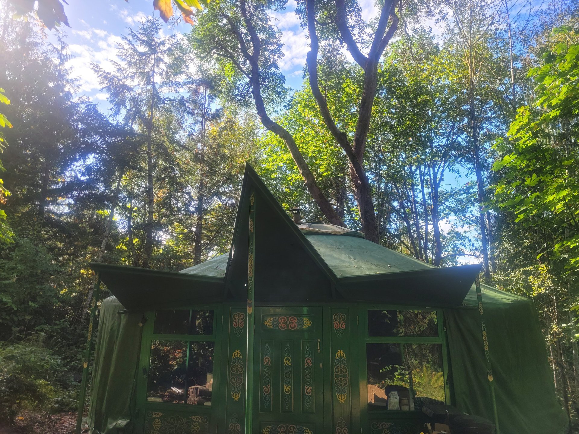 a yurt in the mountains with a yellow door
