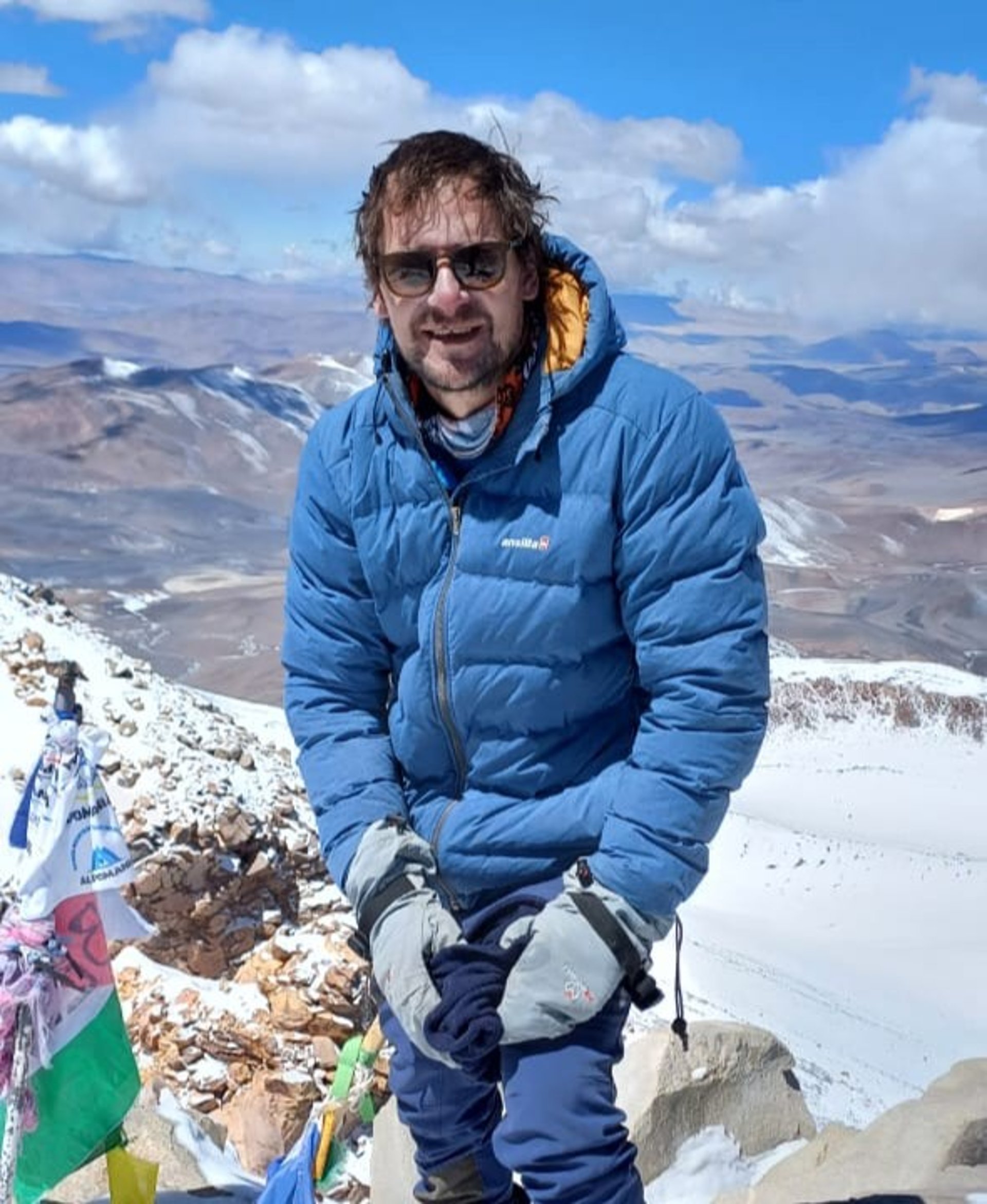 man in black and red jacket standing on snow covered ground