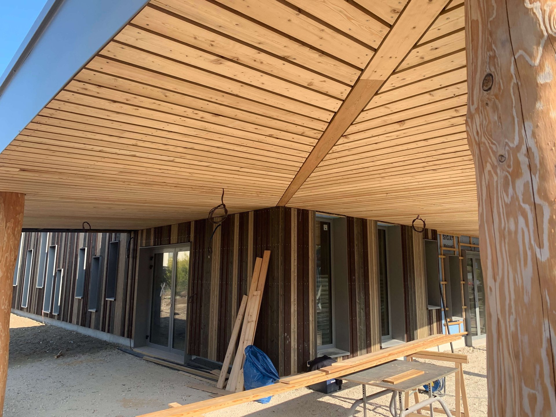 Roof tiles are being installed on a wooden frame.