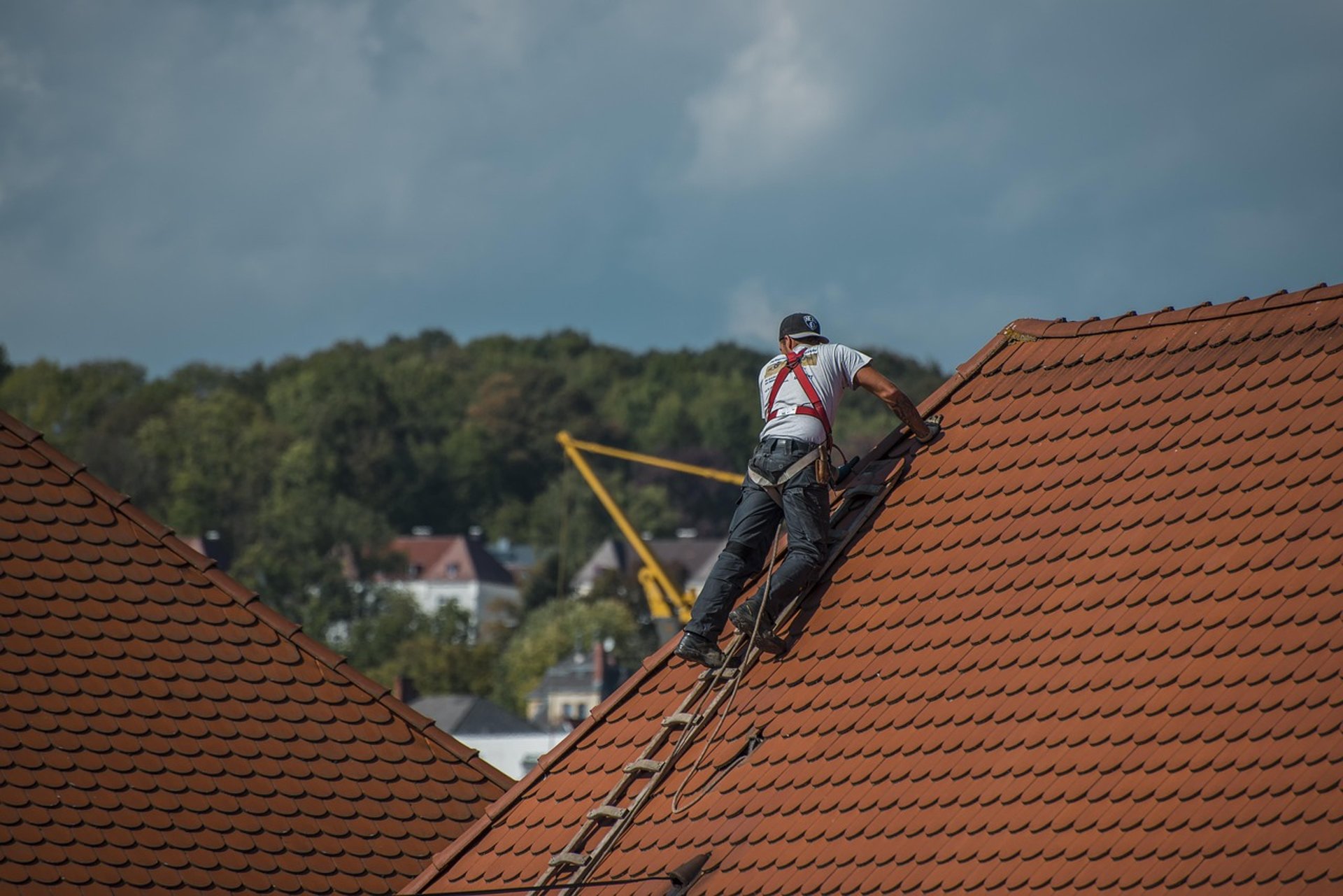 Roof tiles are being installed on a wooden frame.