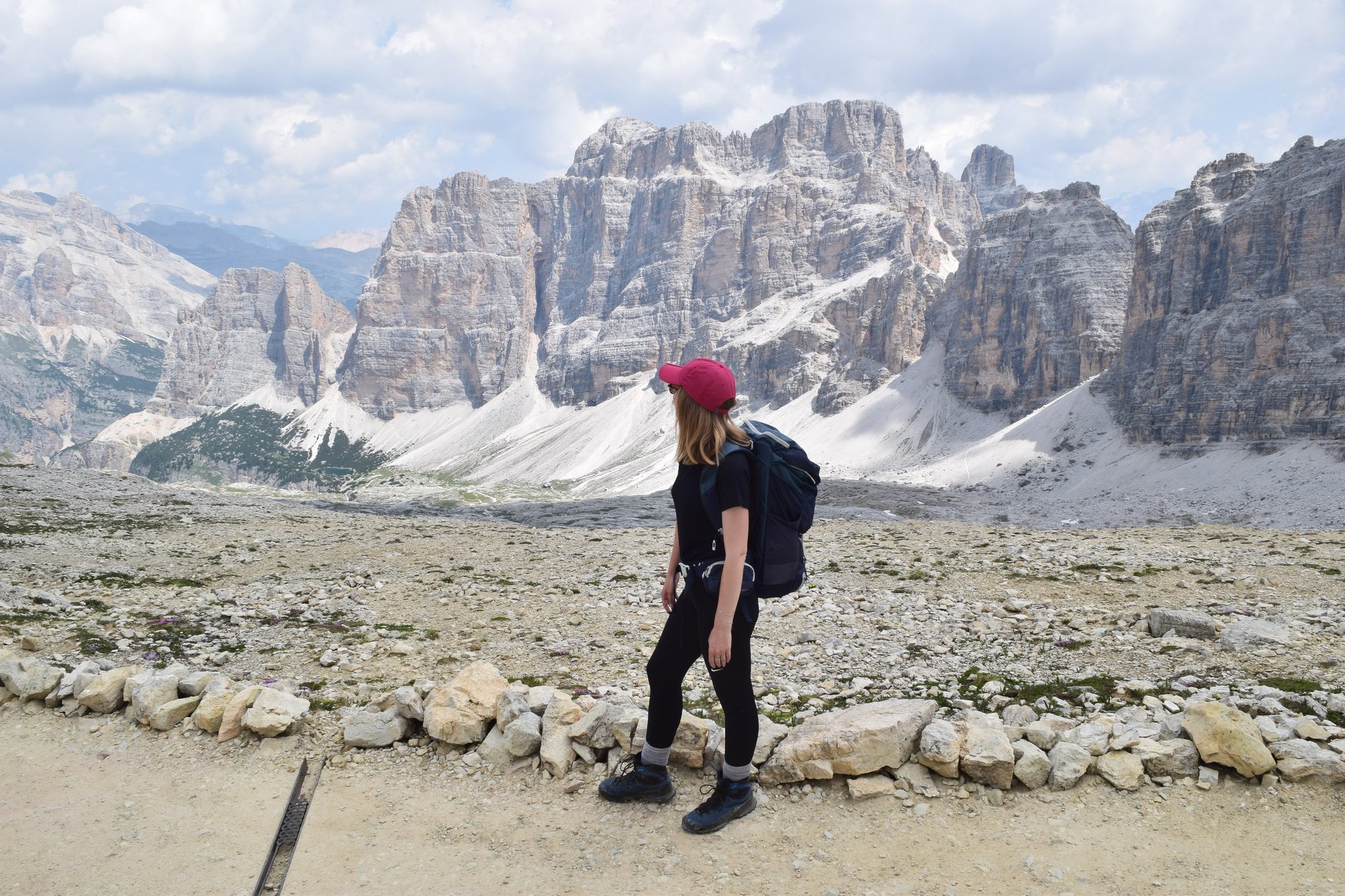 a woman standing on top of a mountain next to a waterfall