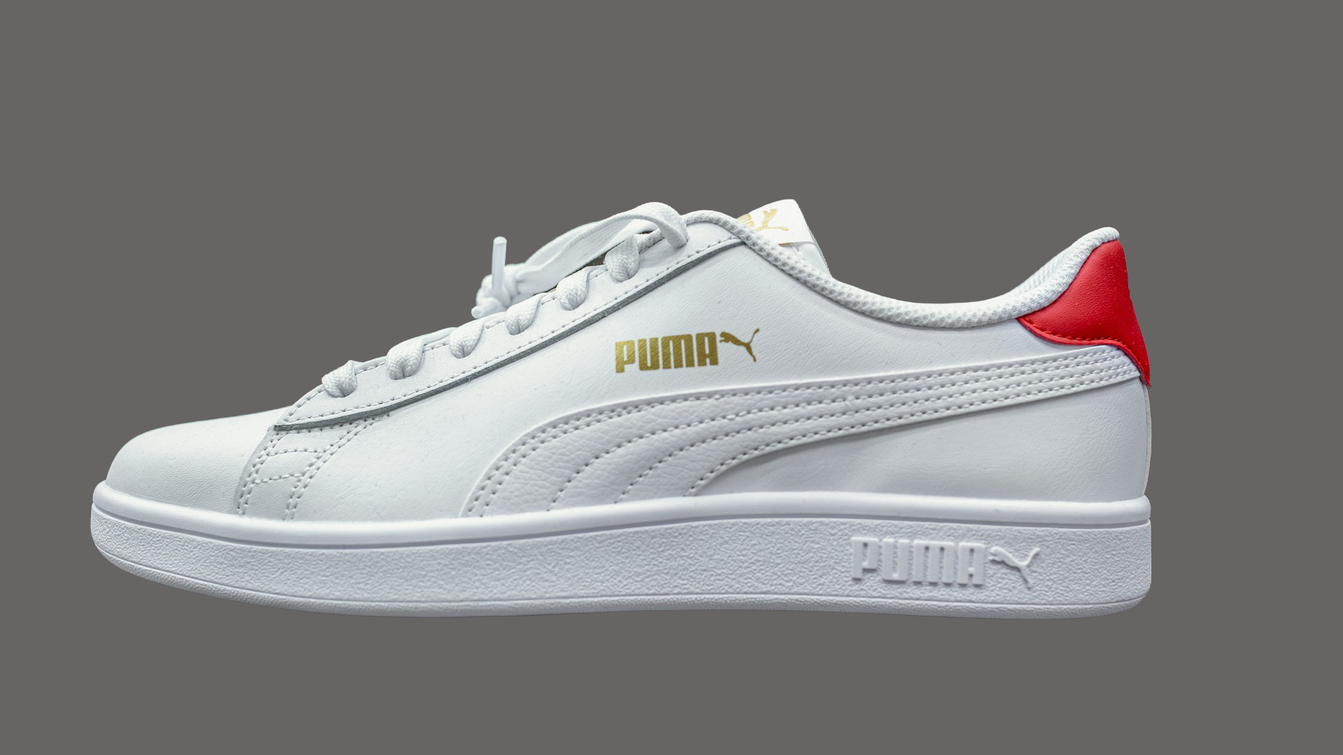 a white and red puma sneakers sitting on top of a table
