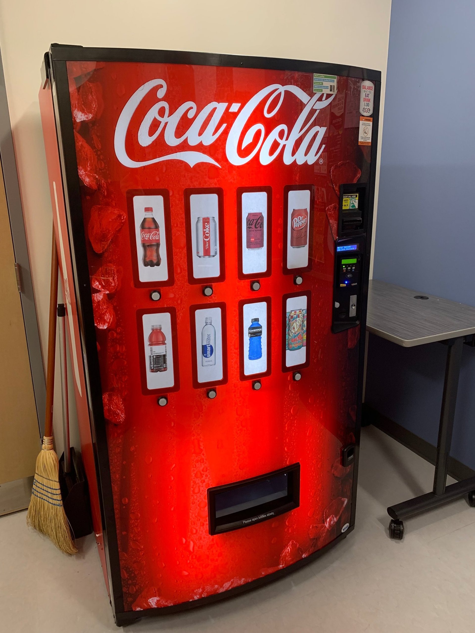 black and blue vending machine beside brown wooden cabinet