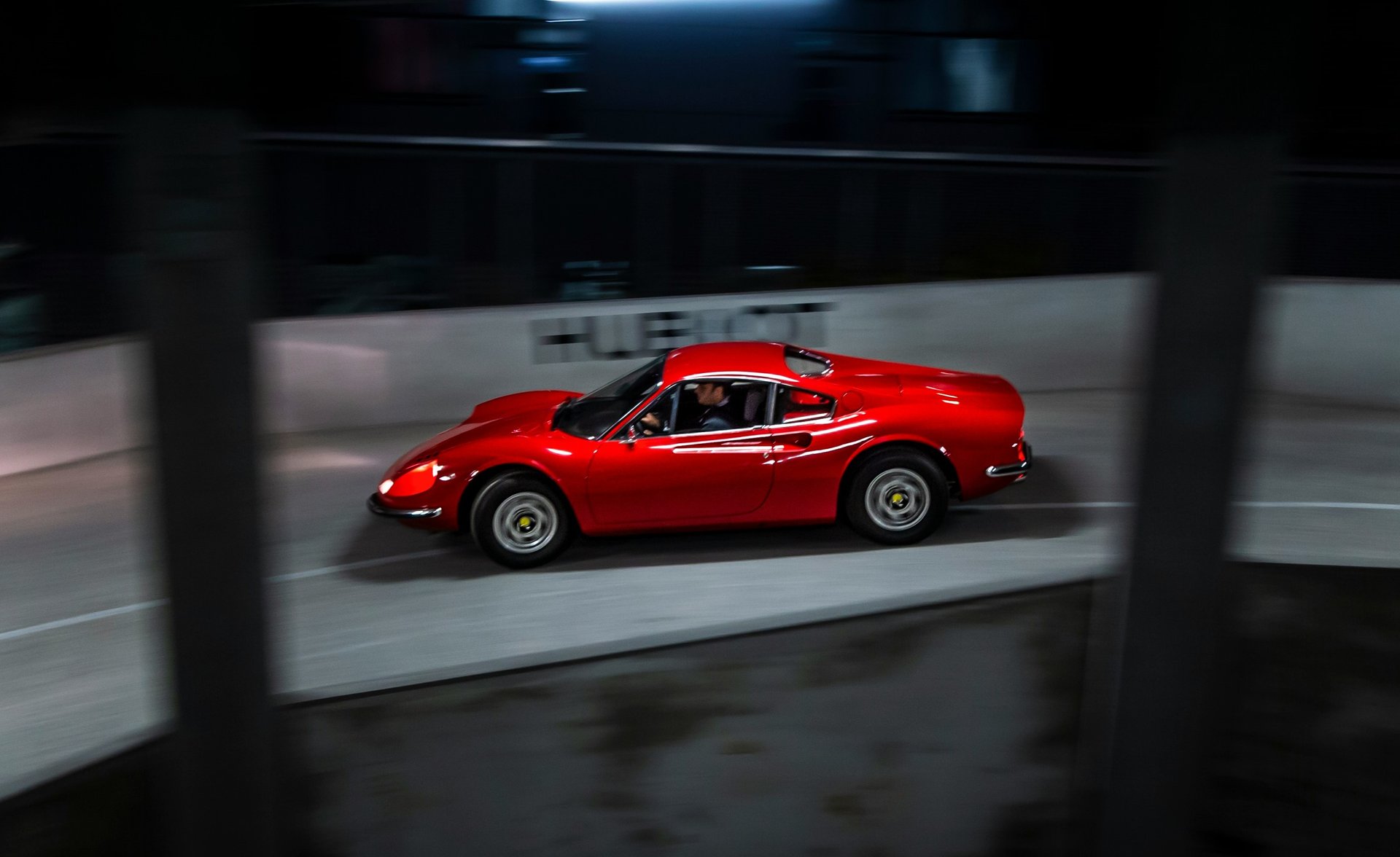 two vintage cars beside gray concrete wall