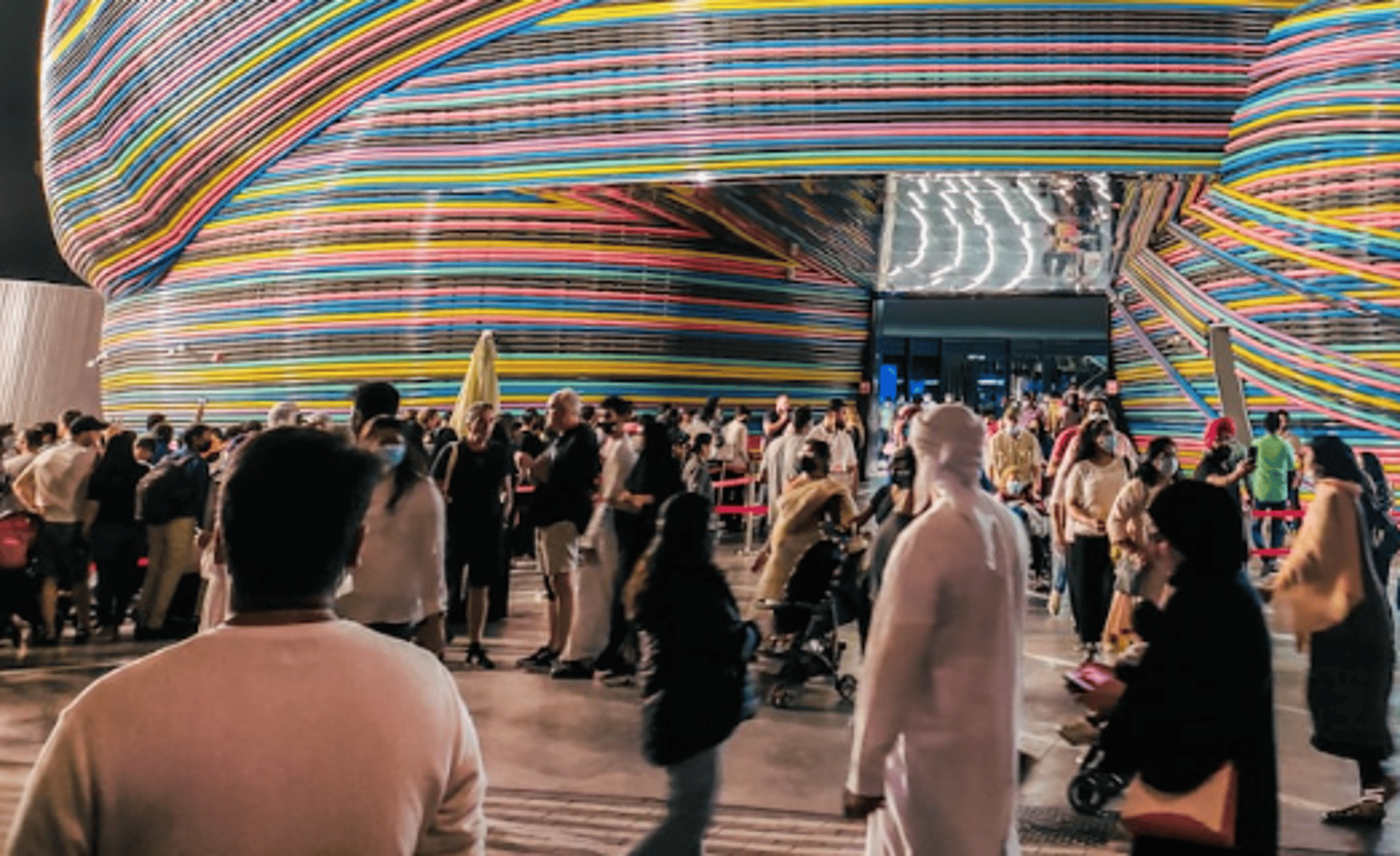 a colorful building with people walking around it