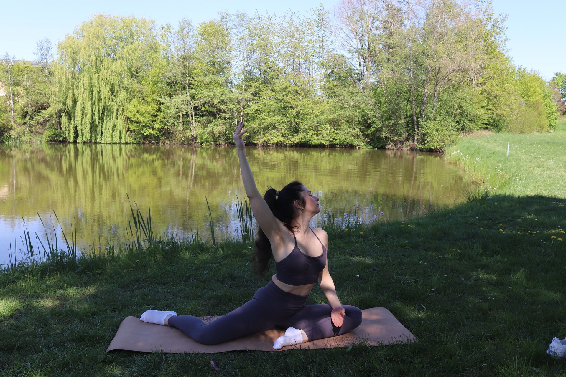 woman in black tank top and black pants bending her body on floor