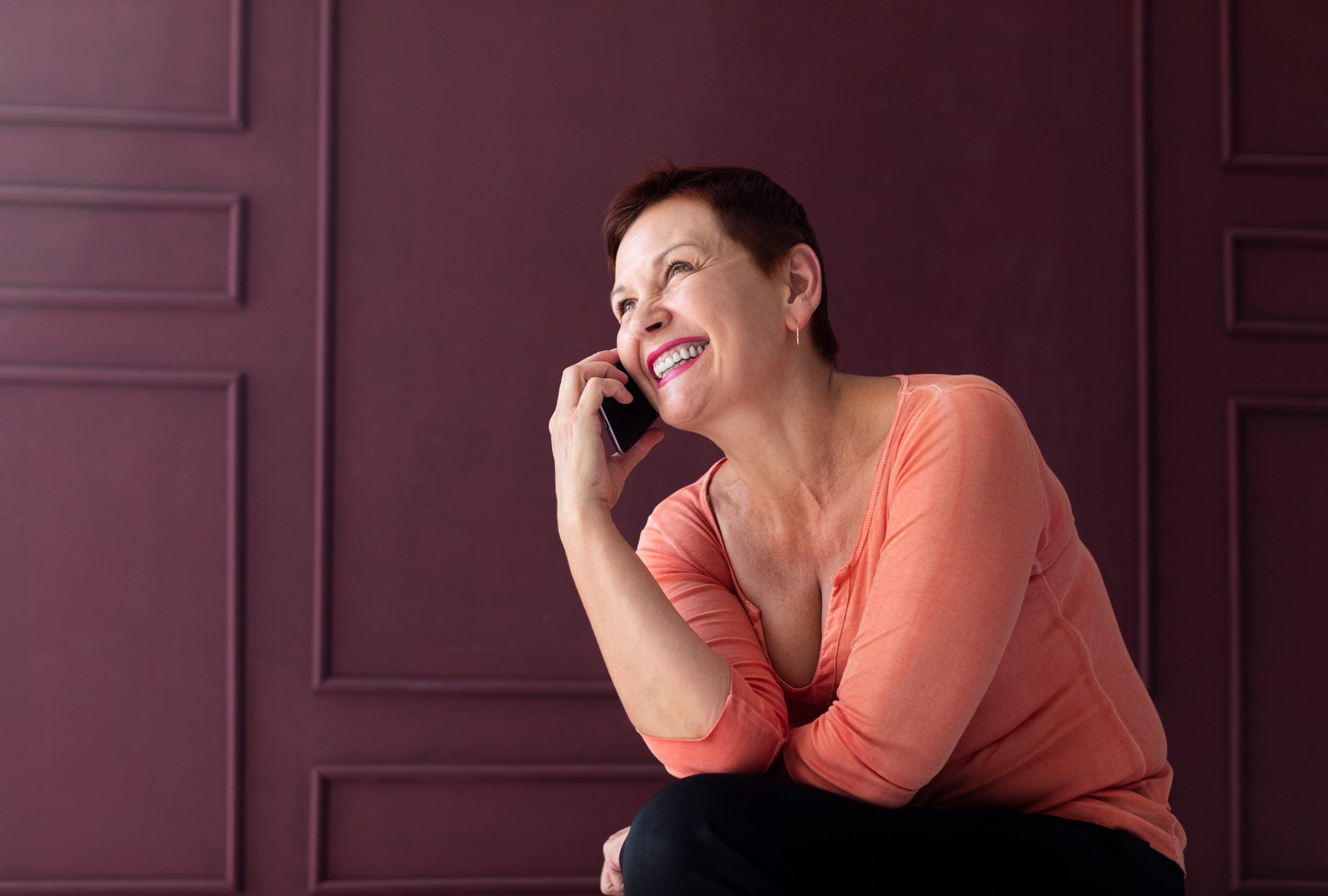 a woman laying on a bed looking at a cell phone