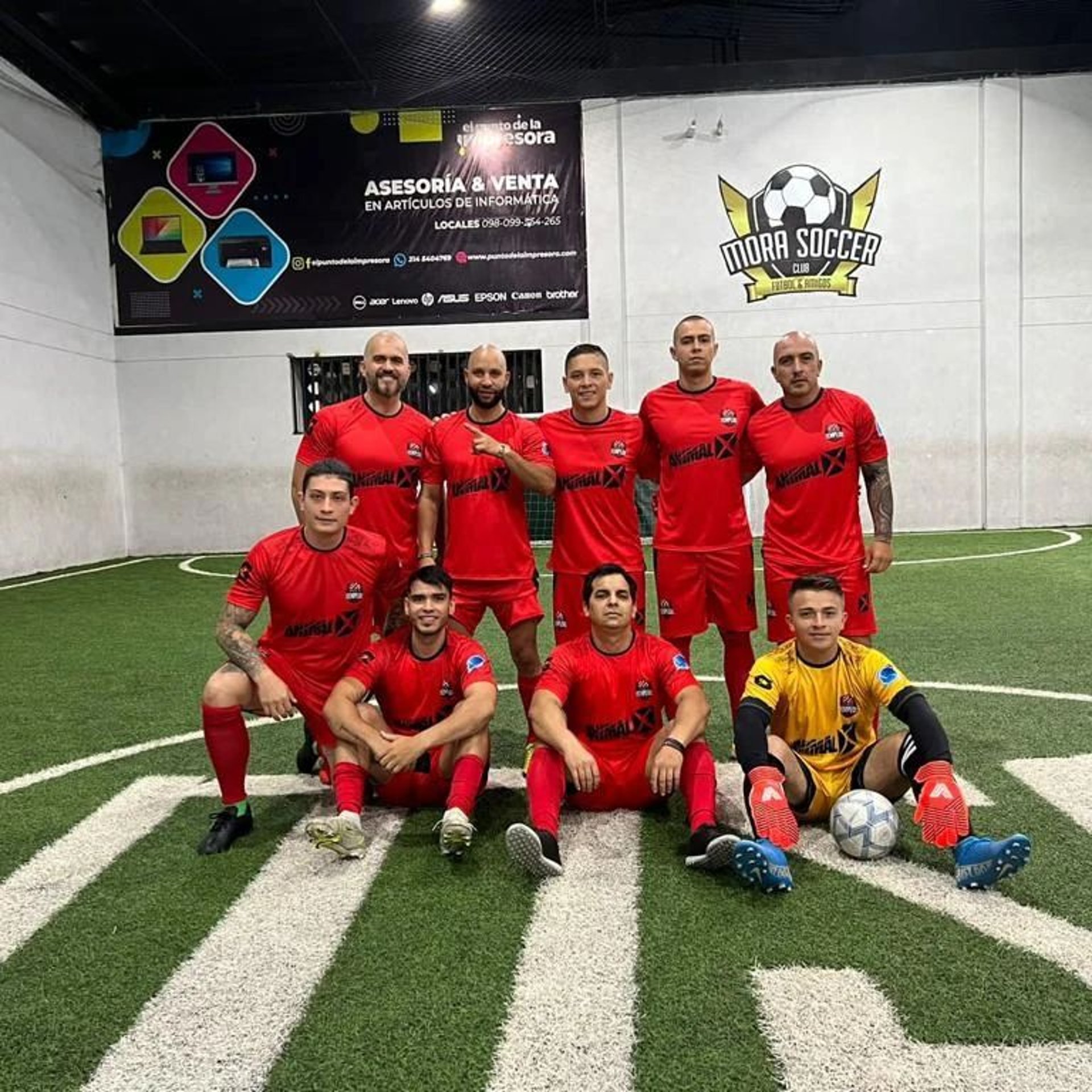 A soccer team poses proudly on the field.