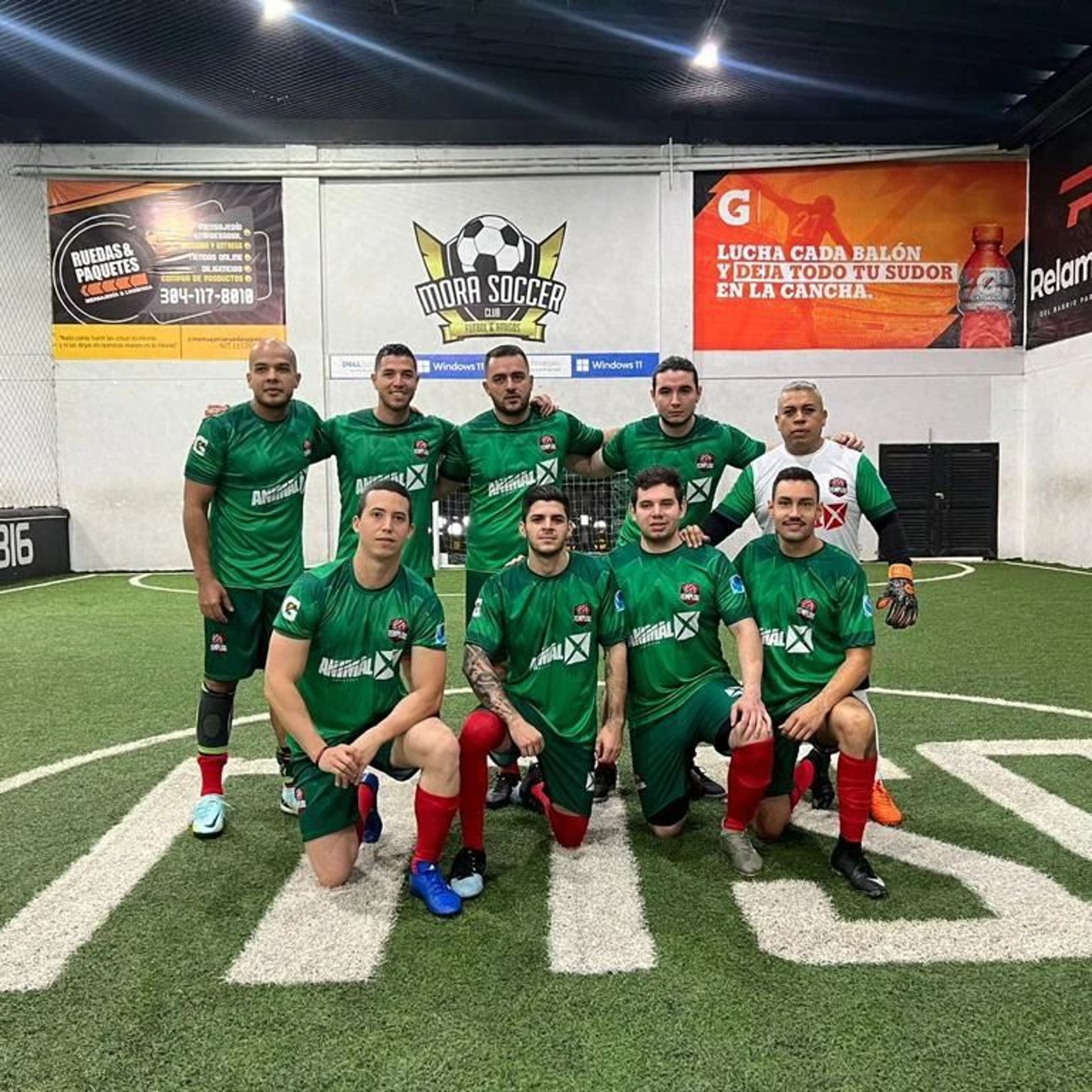 A soccer team poses proudly on the field.