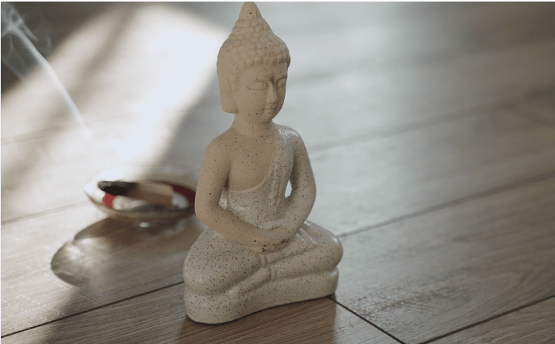 a statue of a buddha sitting in the middle of a forest