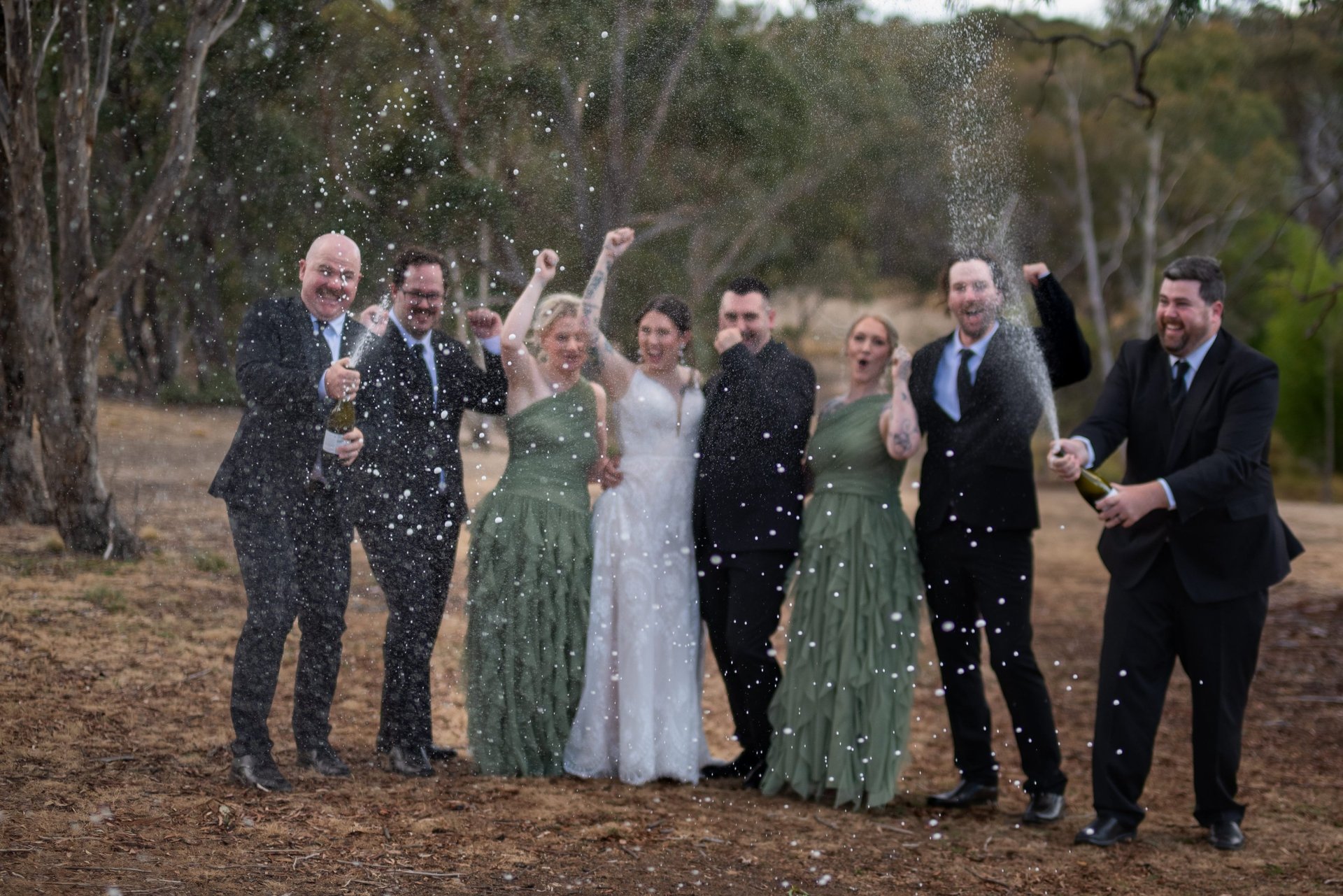 Bride and groom standing together smiling, black and white image with big tree in the background. Canberra wedding photograph