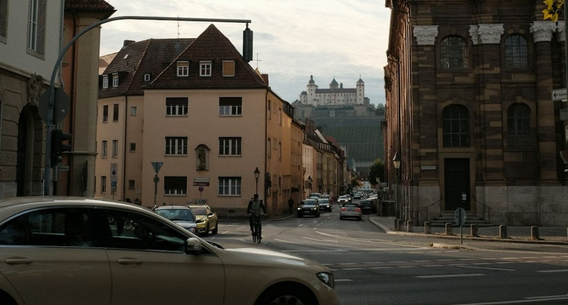 a car driving down a street next to tall buildings
