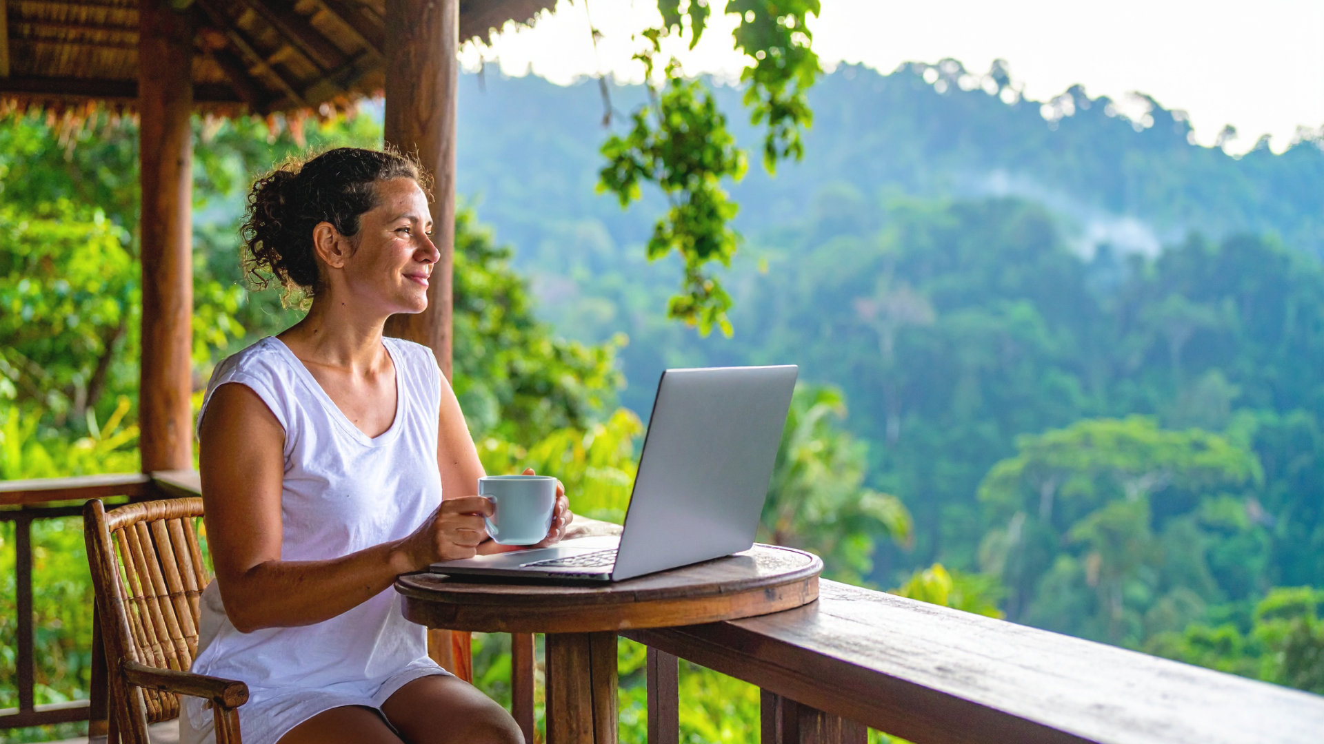 Frau arbeitet entspannt mit Laptop und Kaffee in tropischer Natur – Burnout überwinden und ortsunabhängig ein freies Online-B
