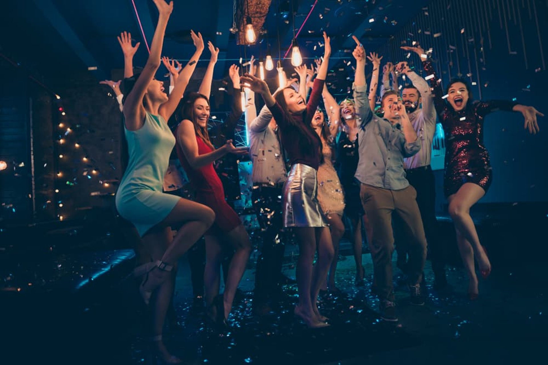 Excited crowd dancing under confetti in a vibrant DTLV nightlife venue on Fremont Street.