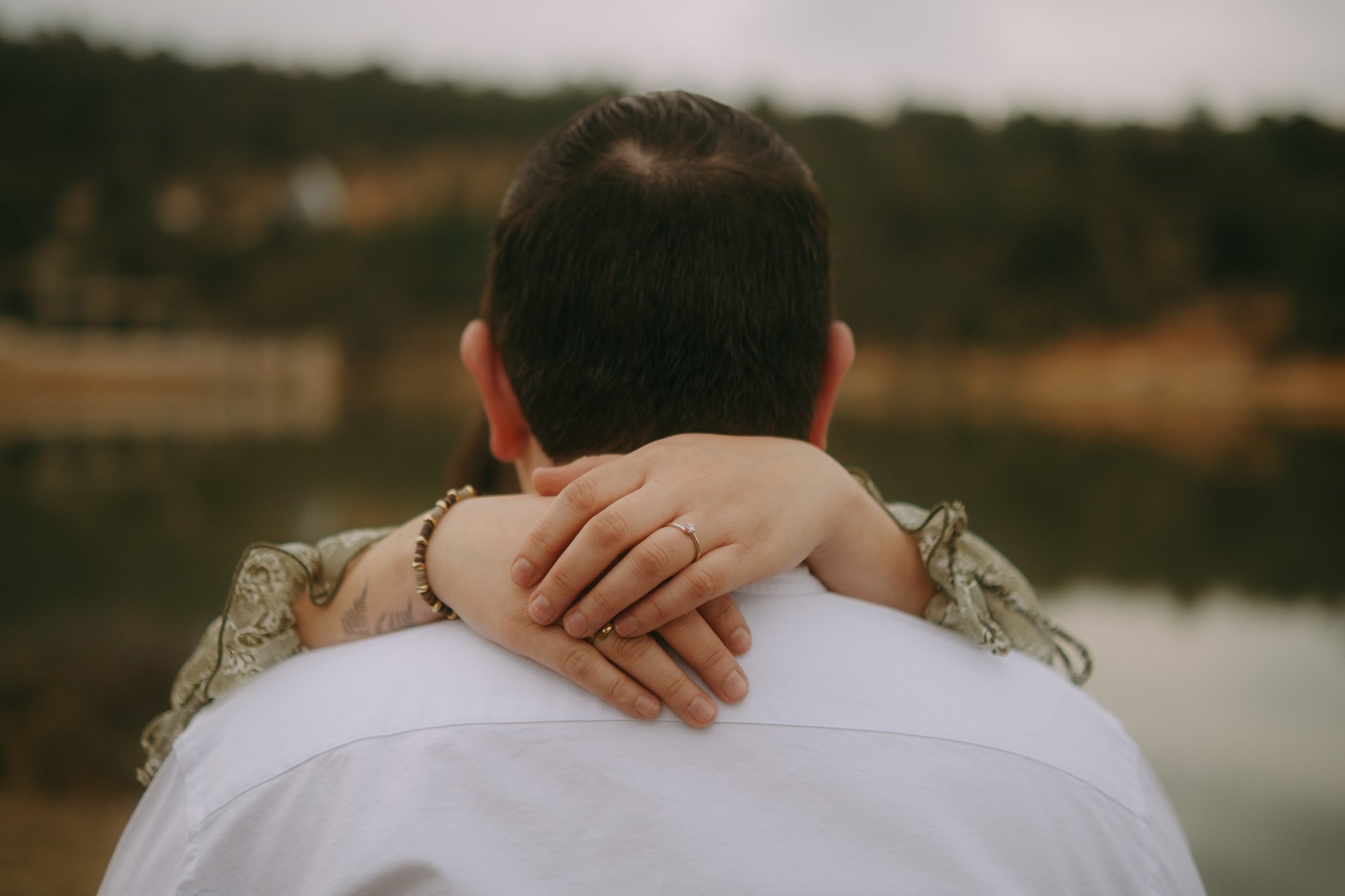 a field of tall grass with trees in the background