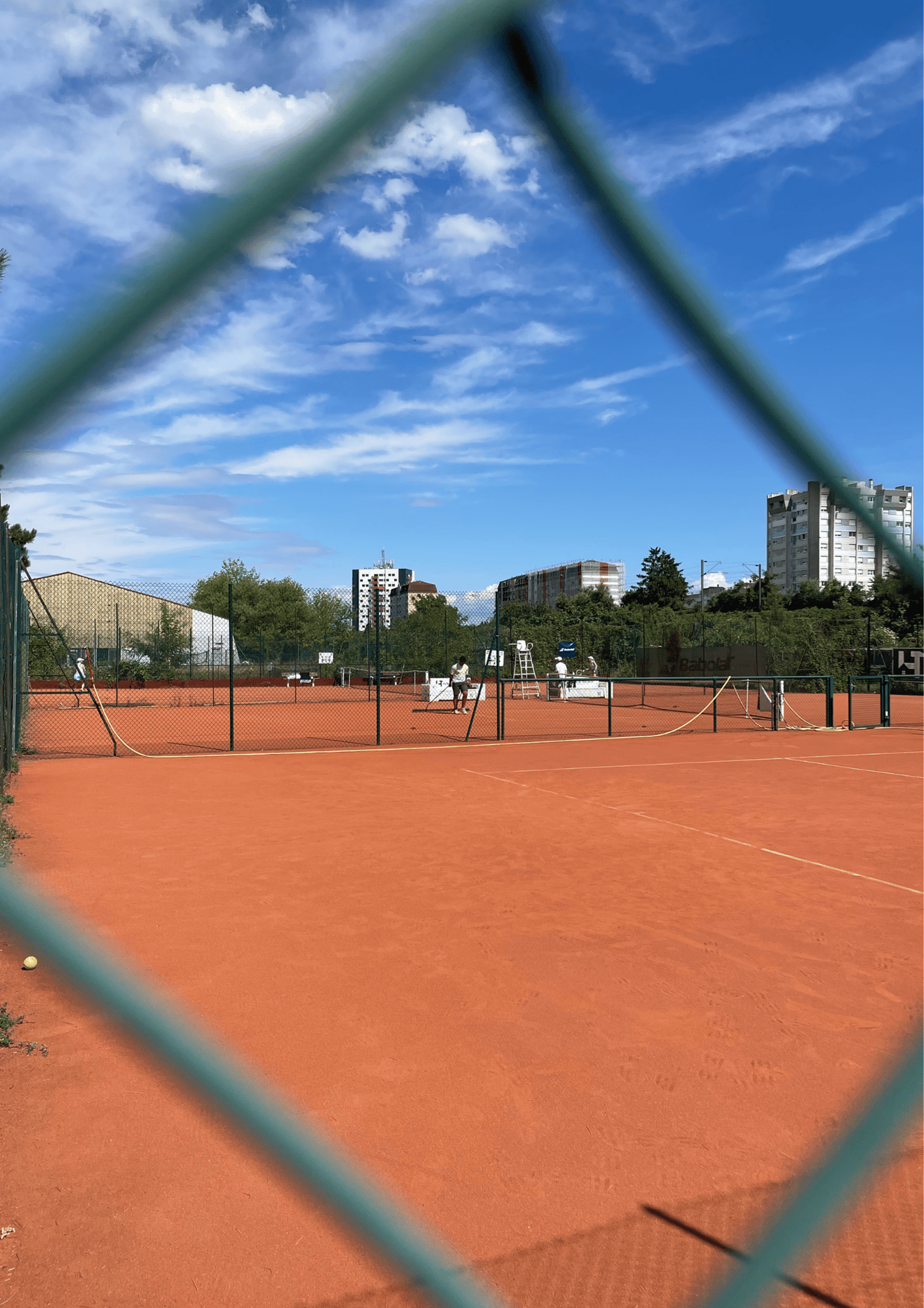 a tennis court seen through a chain link fence