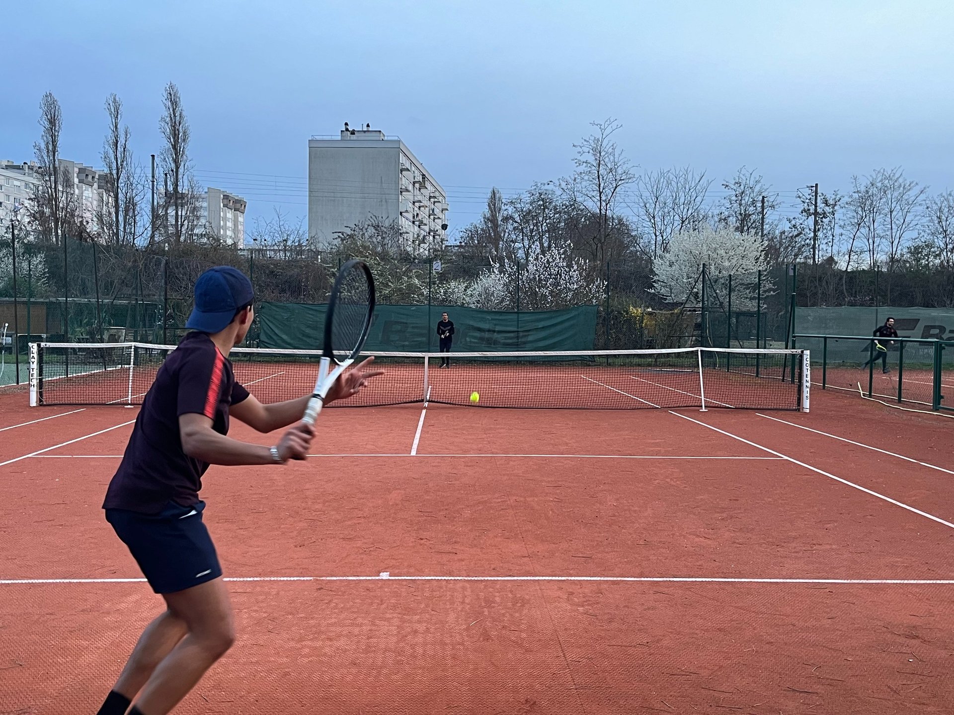 two people playing tennis on a tennis court