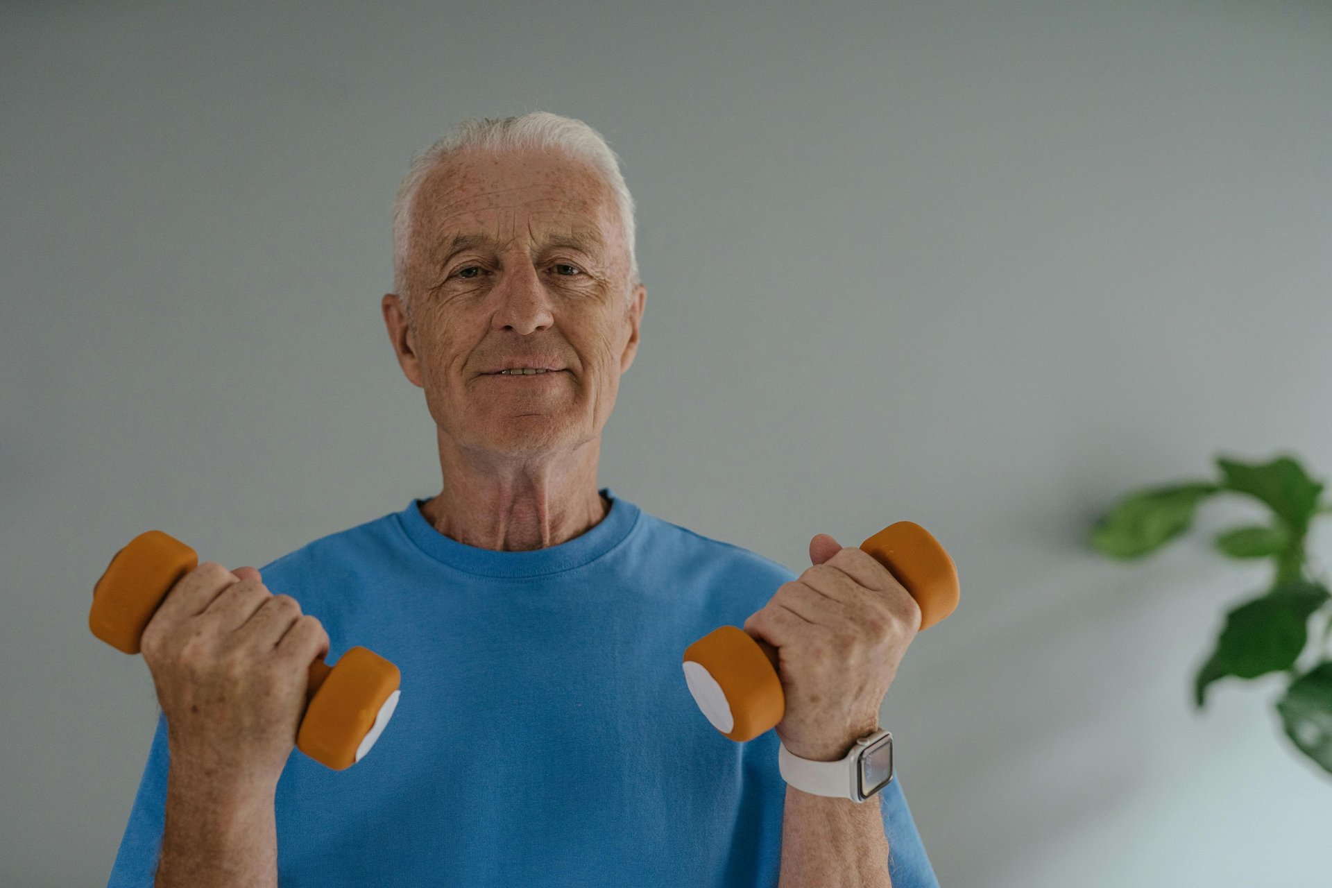 elderly senior adult male lifting weights for exercise