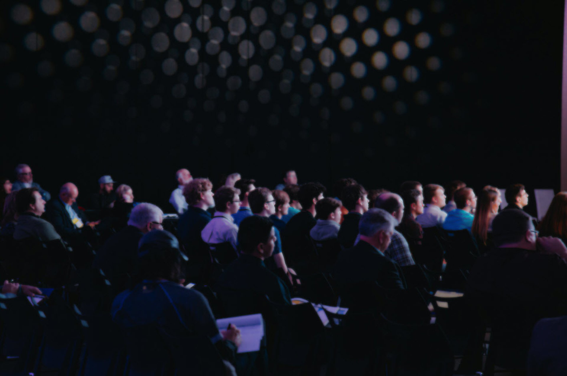 people sitting on chair in front of table while holding pens during daytime