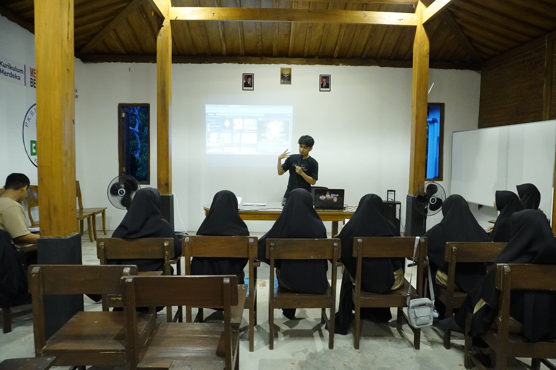 a library filled with lots of books next to wooden tables