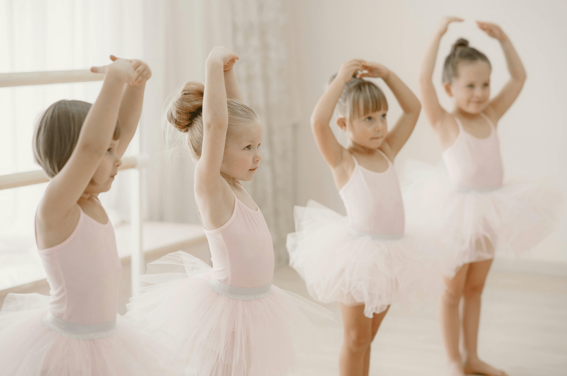 group of ballerinas dancing while raising both hands