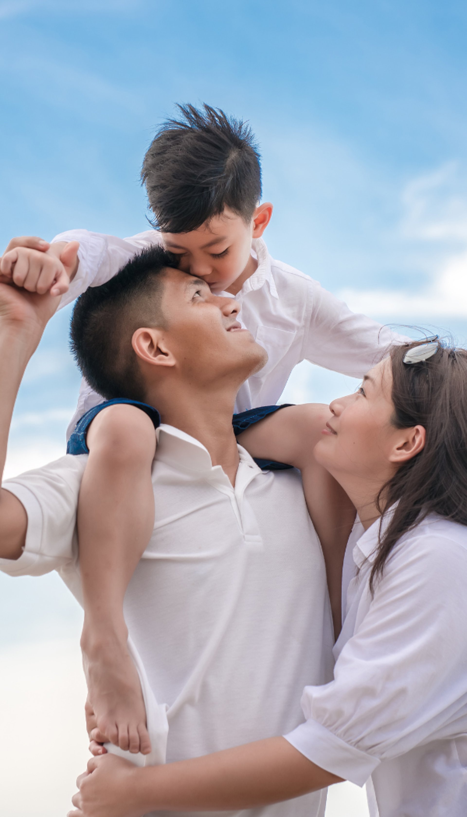 man in white shirt carrying girl in gray shirt