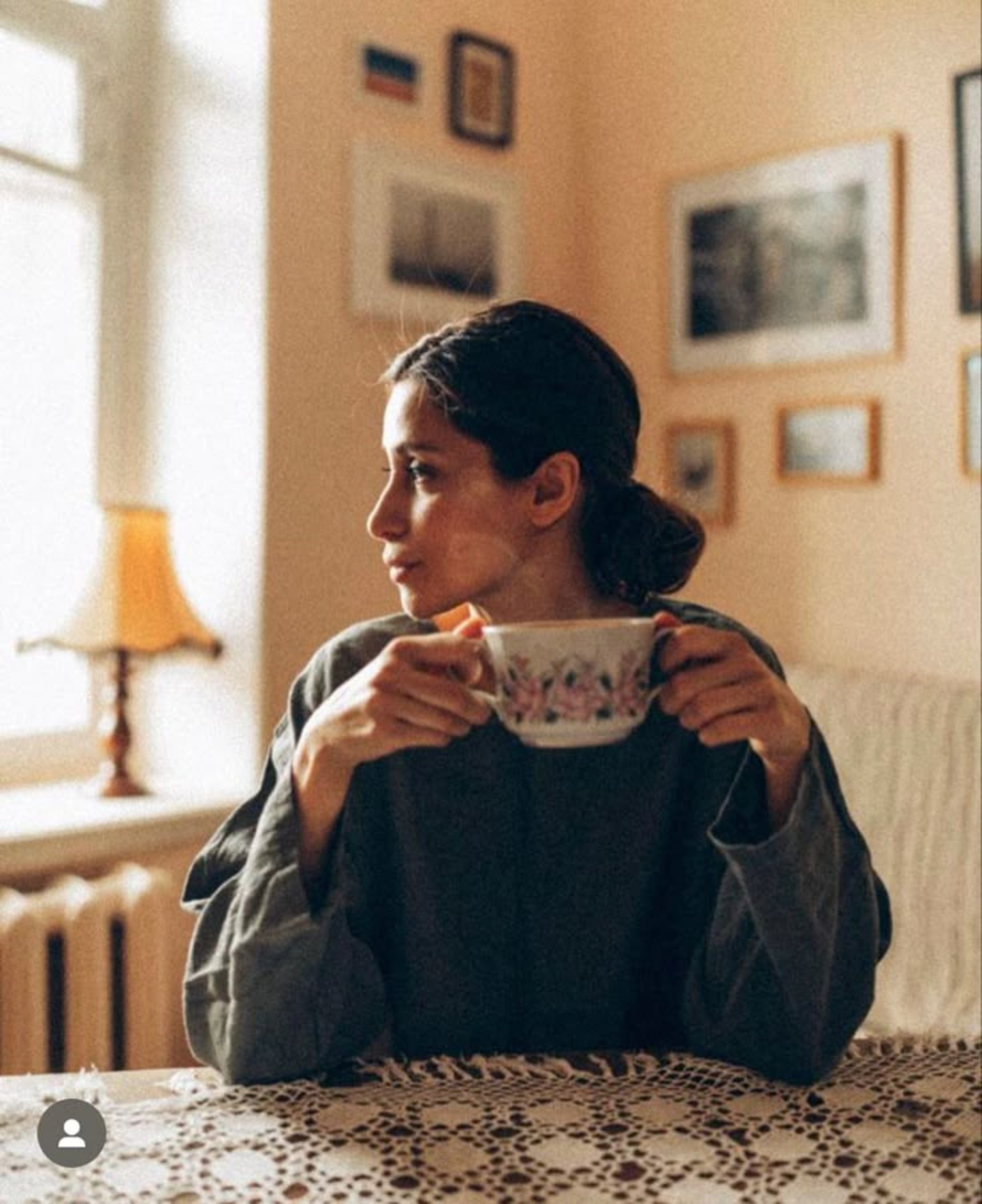 person in red sweater holding babys hand