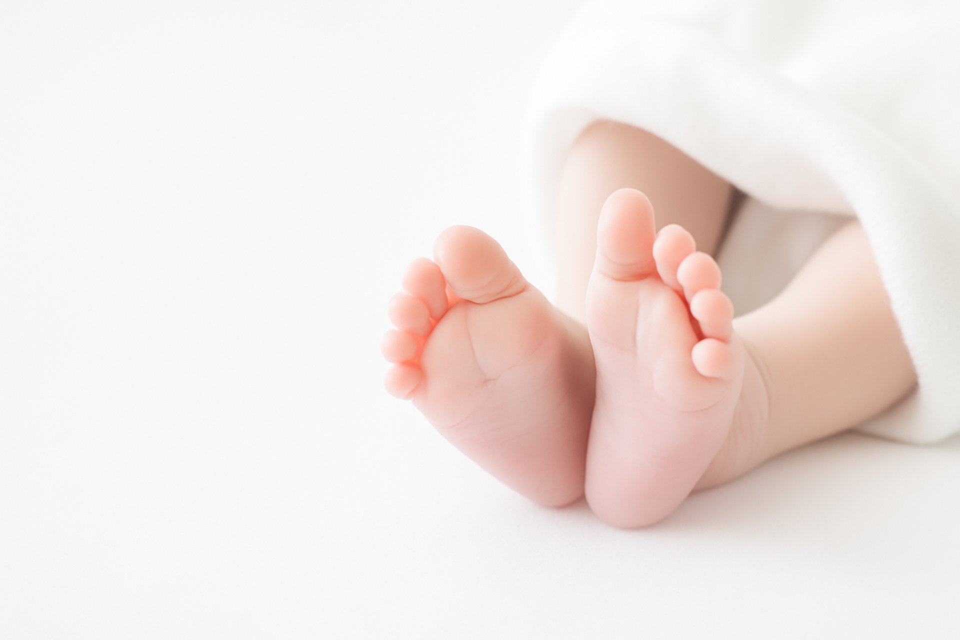 baby covered with white blanket