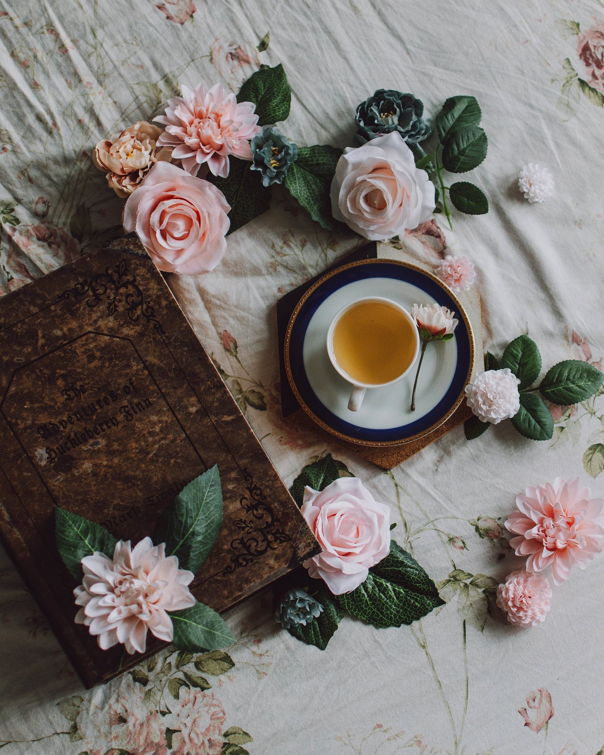 green ceramic mug beside book