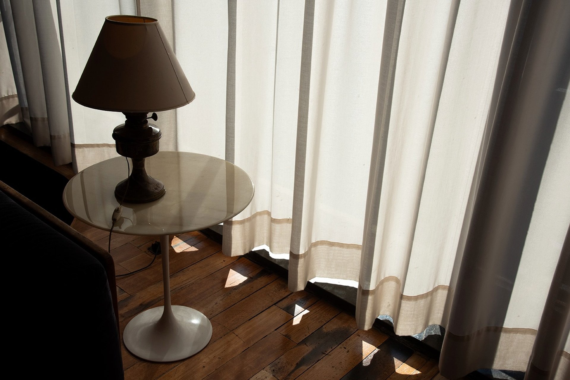 Lampada di design, parquet, tavolino di design, tende bianche, luce naturale hotel design