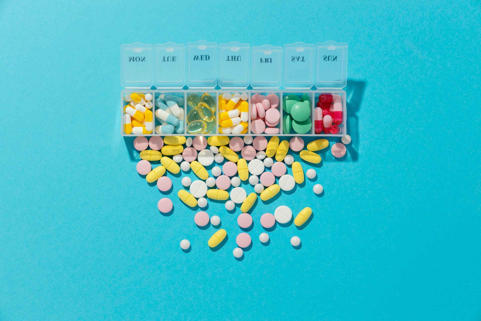 white and blue medication pill on pink textile