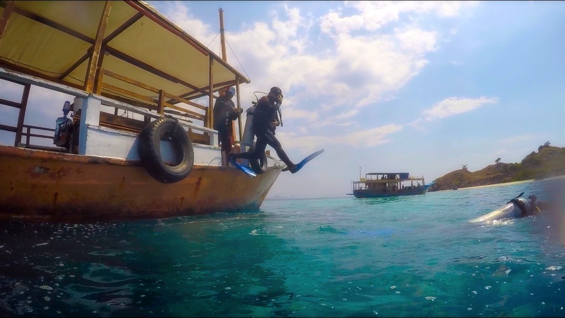 brown and green temple near body of water under blue and white cloudy sky during daytime