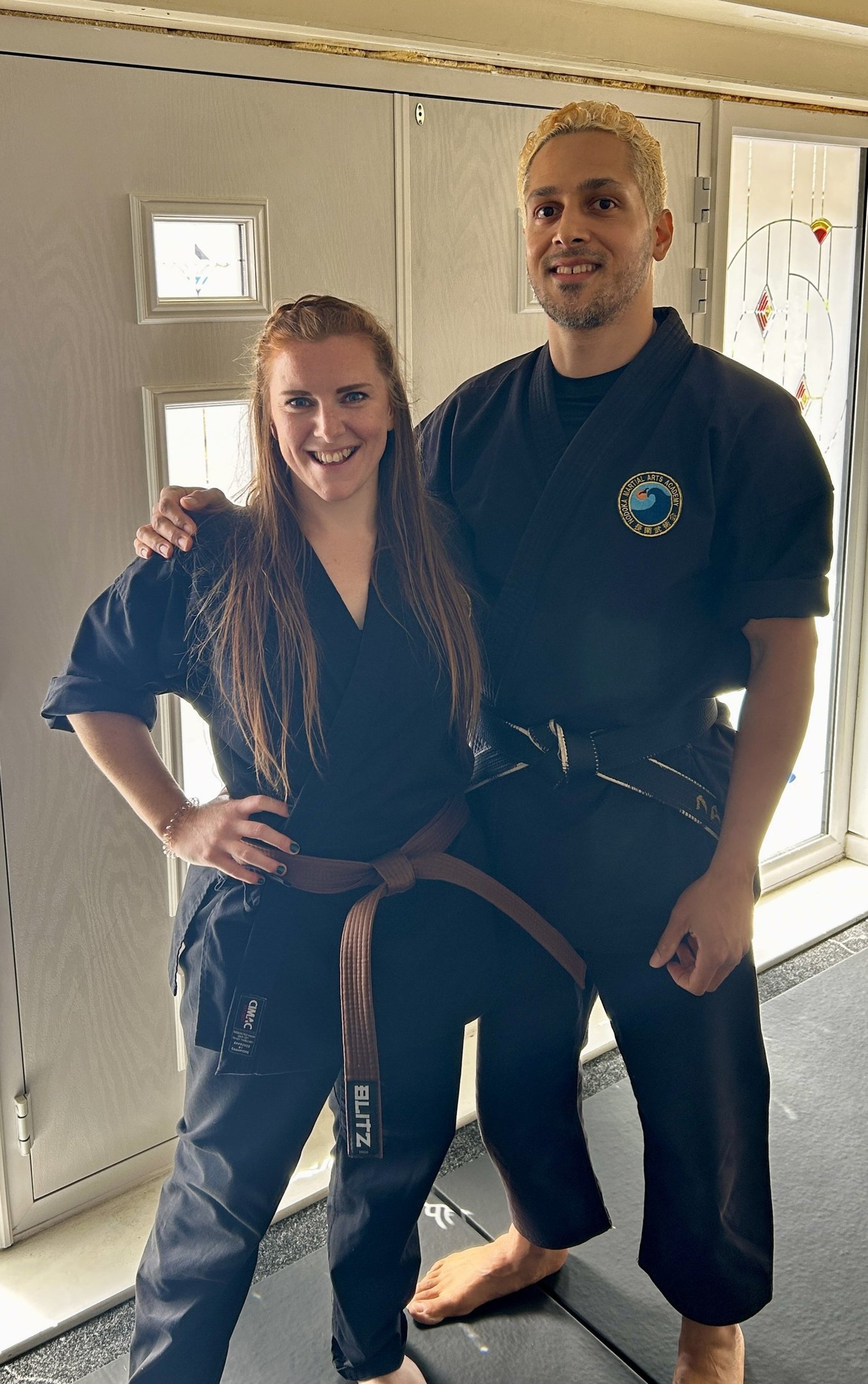 woman in white sports bra and white shorts holding black and white boxing gloves