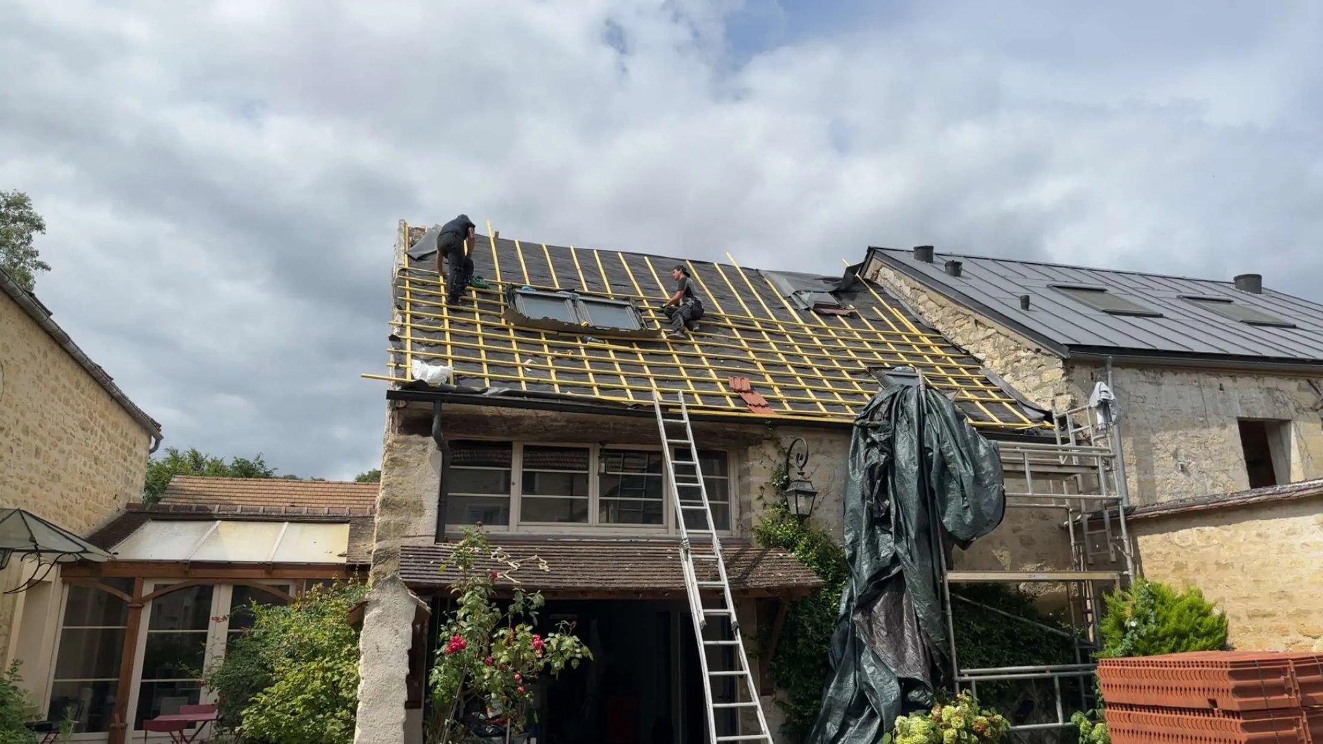 Rénovation de toiture à Saint-Germain-en-Laye — liteaux posés et fenêtre de toit en place, accès par échelle