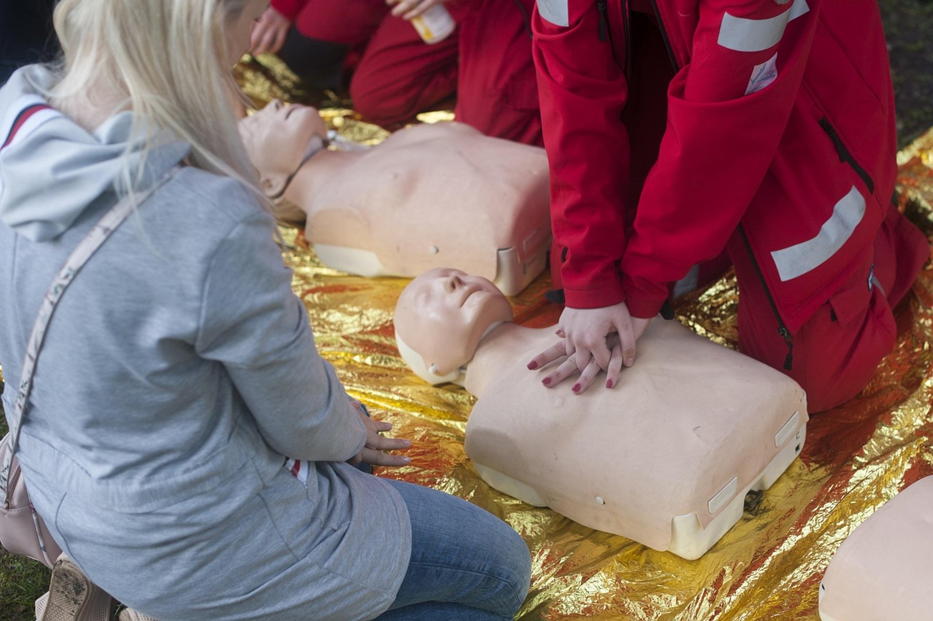 First aid course with medical staff practising CPR on dummies