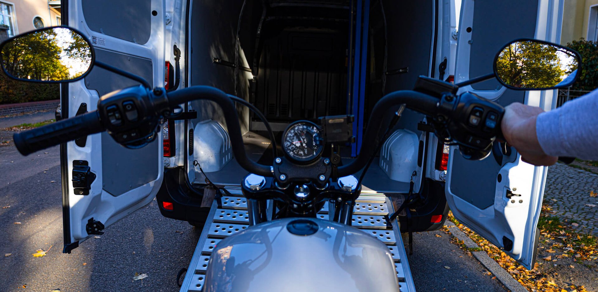 Motorrad wird über Rampe in Transporter verladen