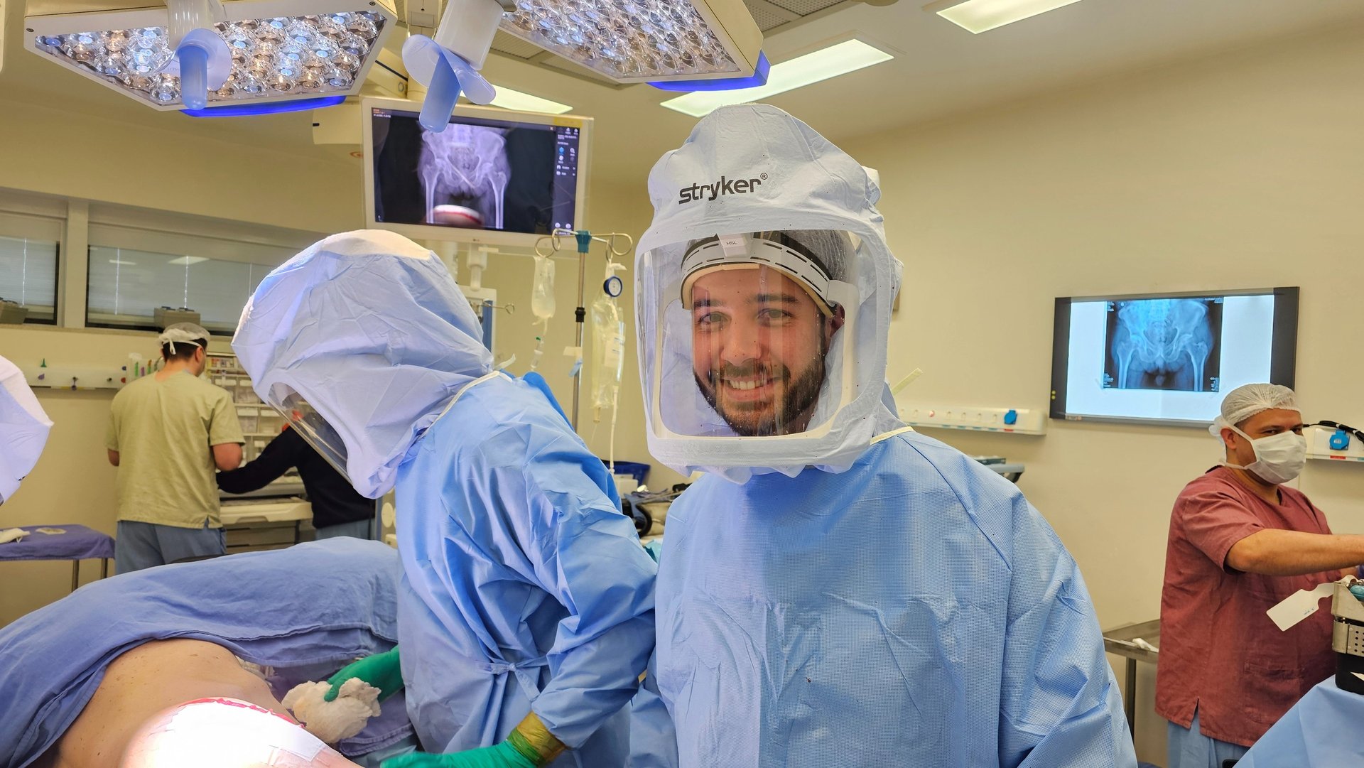 Dr. Gabriel Benevides utilizando capacete cirúrgico de alta tecnologia durante procedimento de artroplastia do quadril.