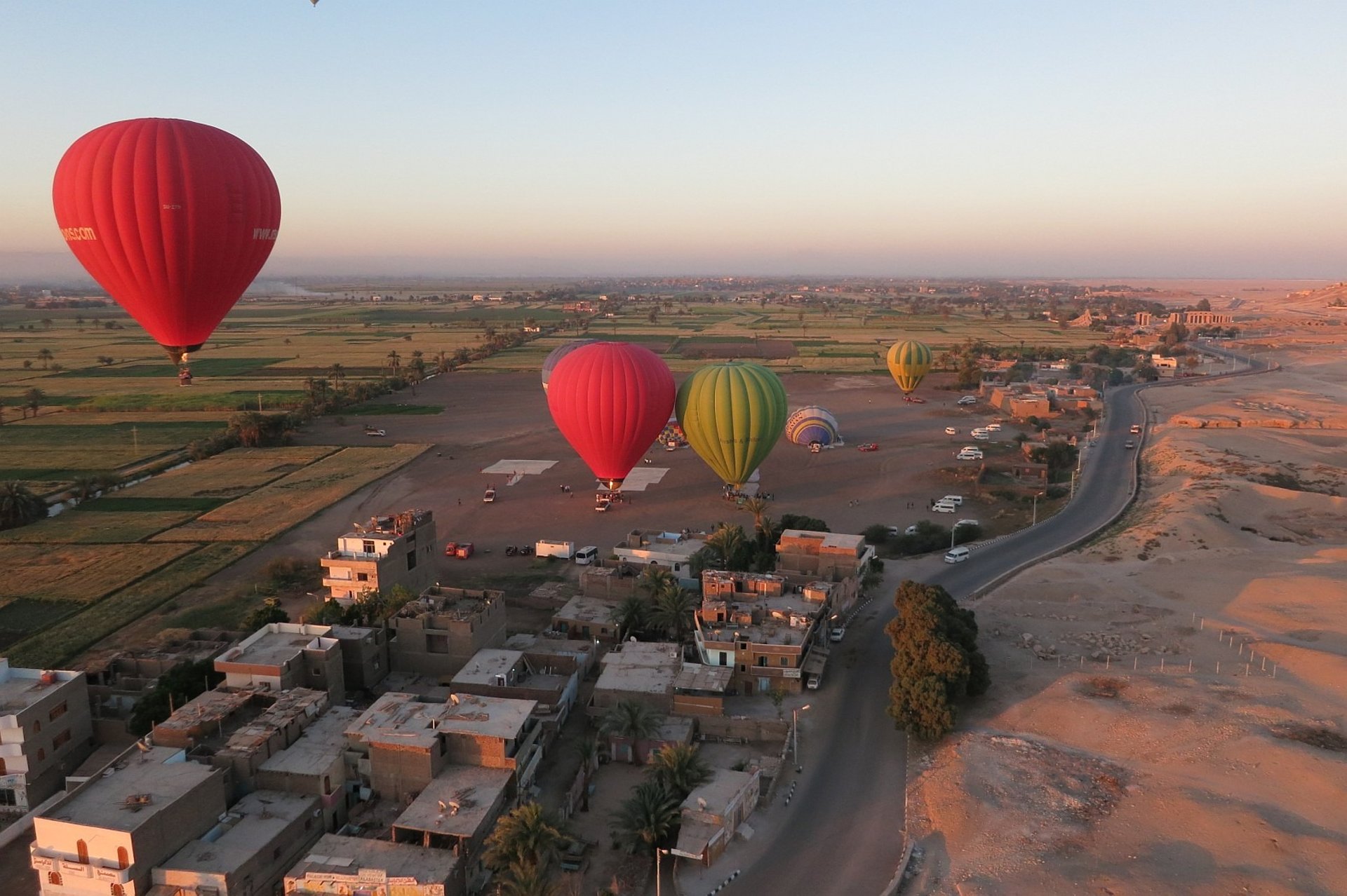 A group of hot air balloons flying over a desert