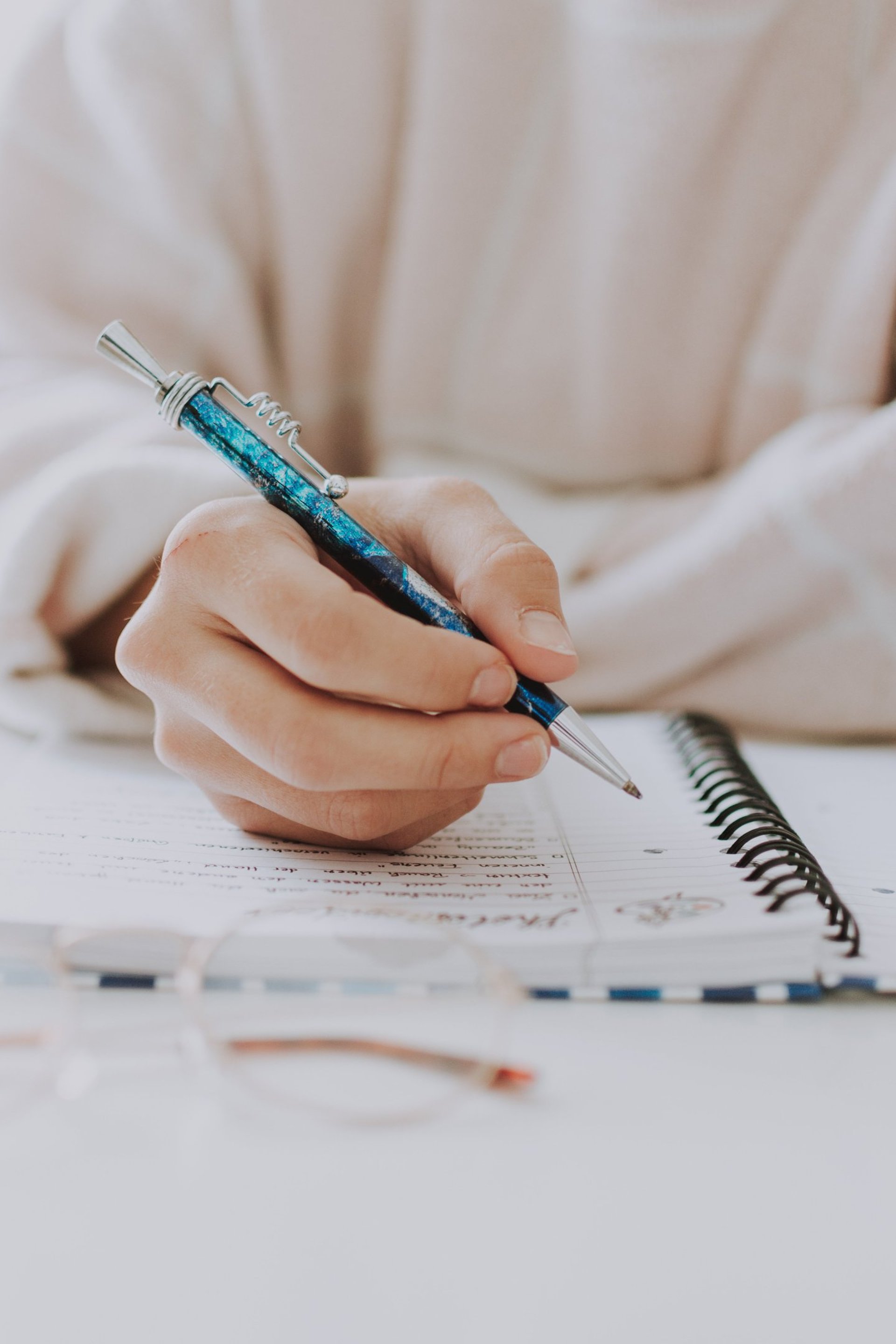 Close-up of a hand holding a blue pen undertaking a dyslexia assessment